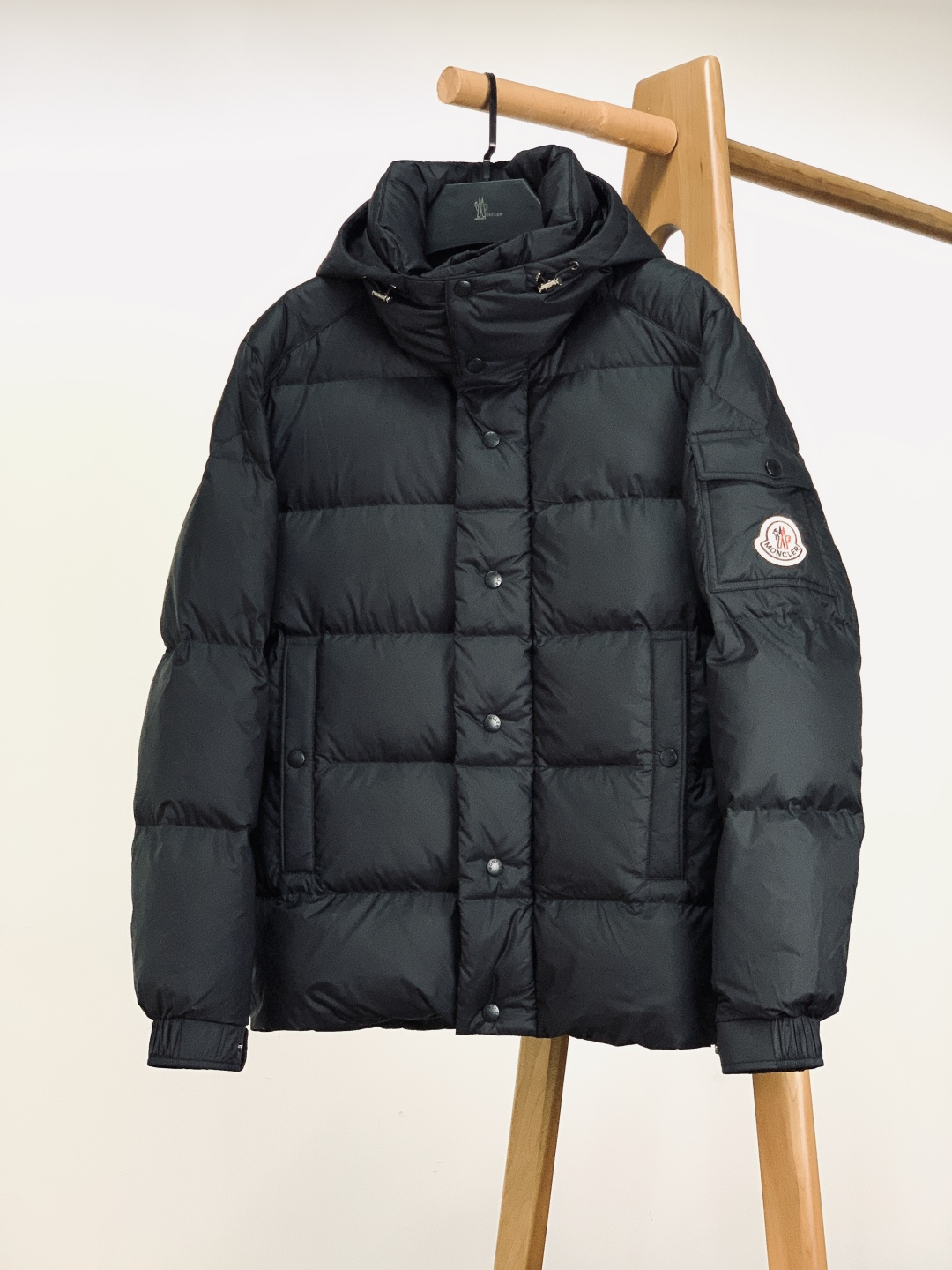 Moncler 蒙口 2025FW秋冬新品黑色连帽羽绒服。左臂处经典的红白蓝刺绣徽章，是蒙口标志性的“潮