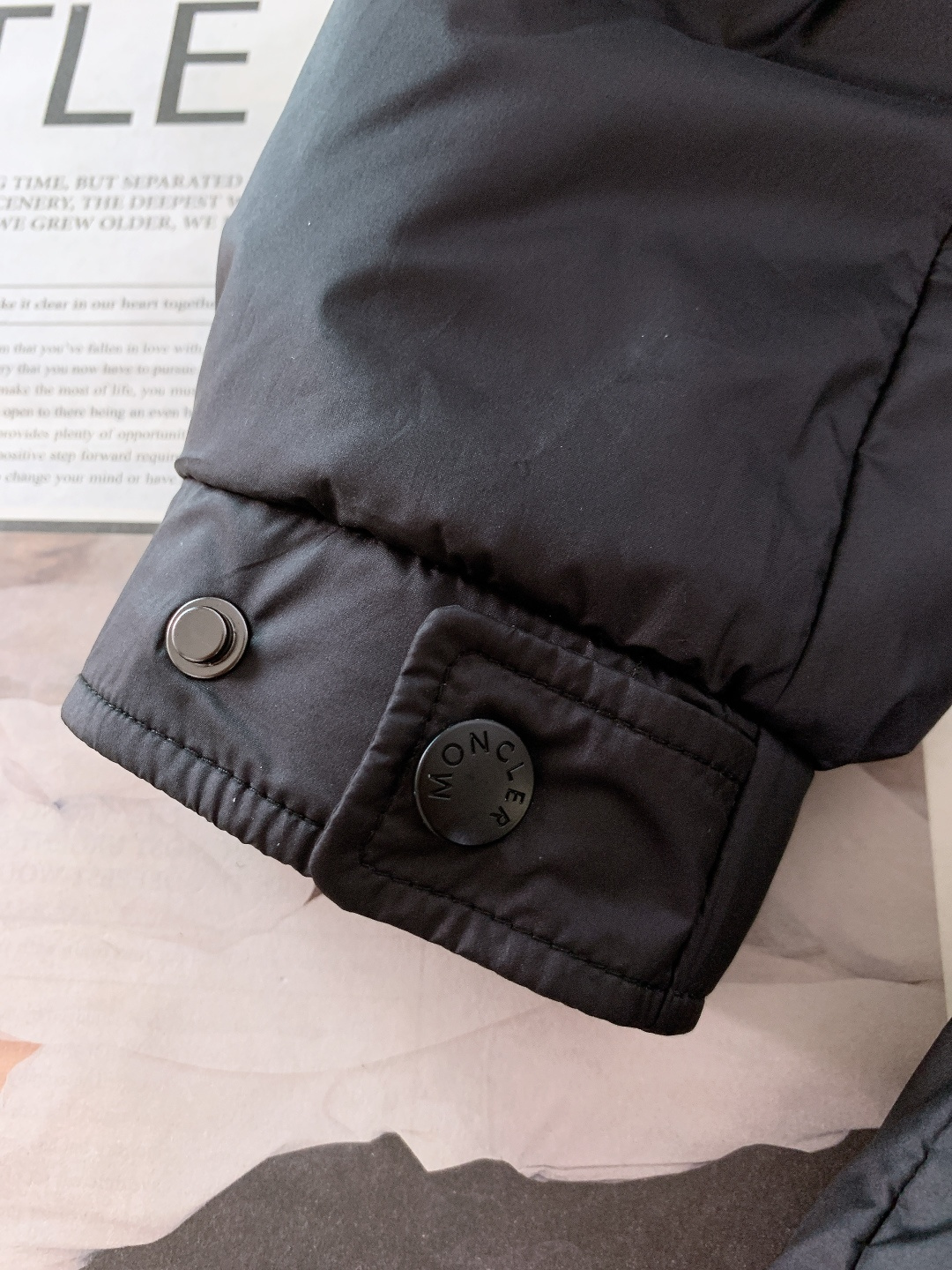 Moncler 蒙口 2025FW秋冬新品黑色连帽羽绒服。左臂处经典的红白蓝刺绣徽章，是蒙口标志性的“潮