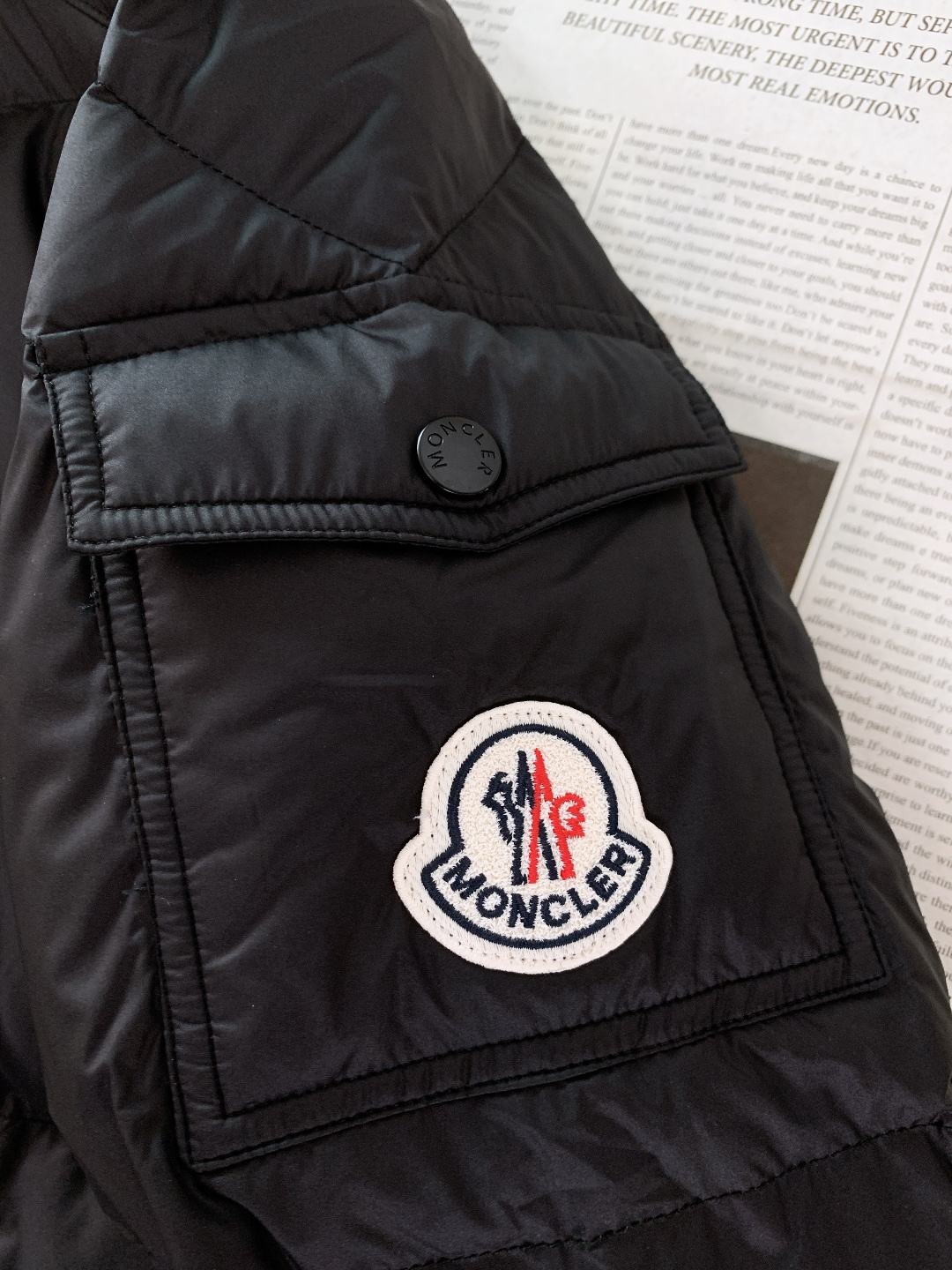 Moncler 蒙口 2025FW秋冬新品黑色连帽羽绒服。左臂处经典的红白蓝刺绣徽章，是蒙口标志性的“潮