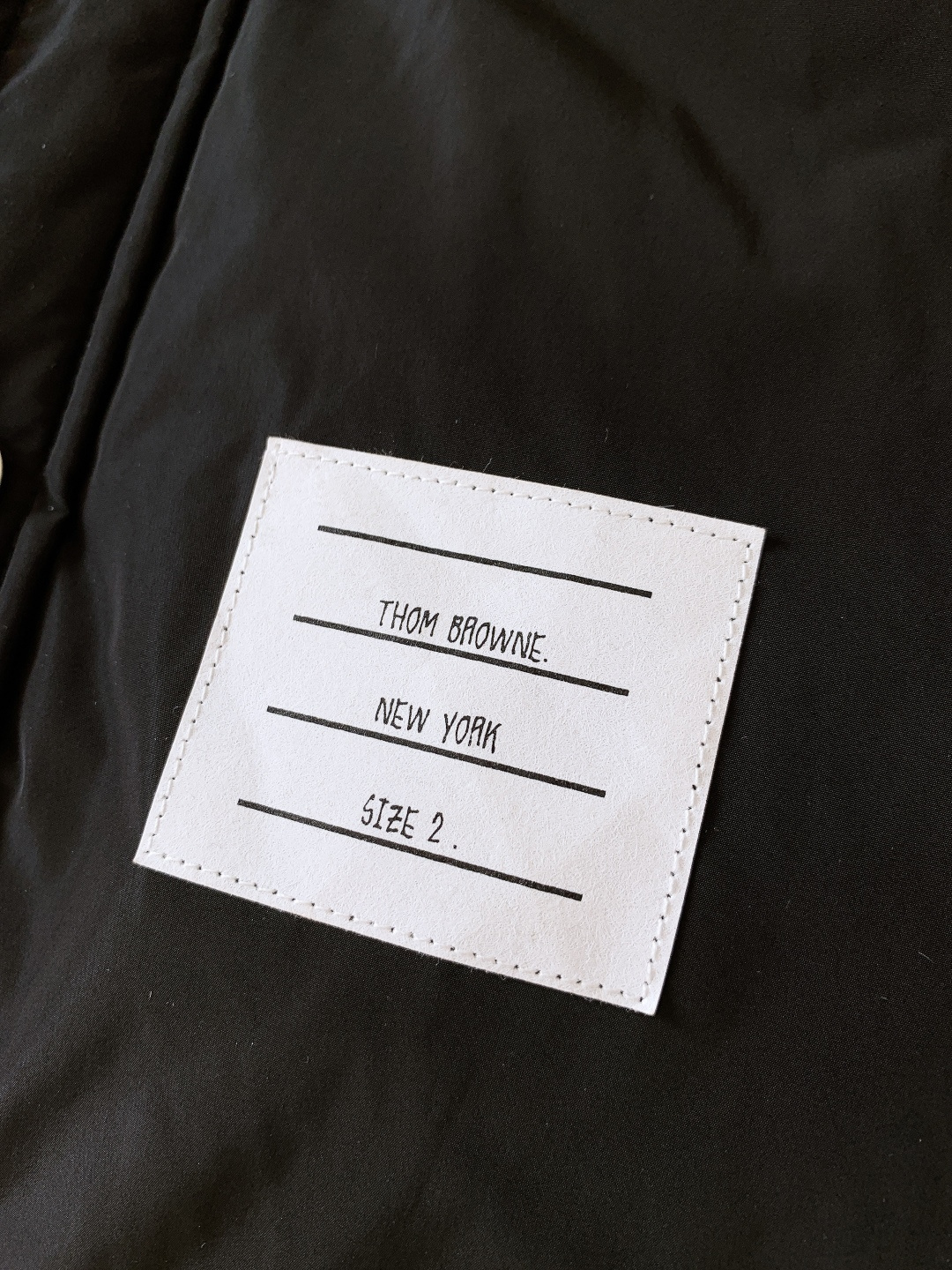 Thom Browne 汤姆·布朗 2025FW秋冬新品 衬衫式夹克羽绒服。面料与保暖：外层是哑光黑细密