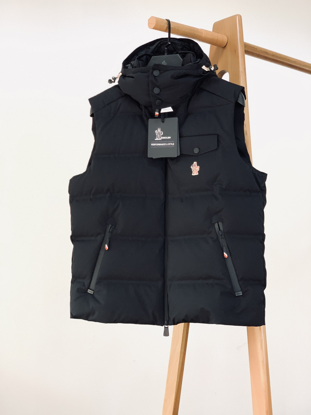 NO:691329,Moncler's 2025FW autumn and winter new product is a hooded down vest. The classic three-color embroidered badge is embellished on the chest work bag, and it is equipped with metal snaps with engraved logo, which makes the brand recognizable. The multi-layer snap buttons on the hood can adjust the collar wrap, and the engraved drawstring buckle on the hem can freely tighten the waistline, taking into account both style and practicality. The triangular anti-counterfeiting tag and the leather zipper puller are embedded with the brand logo, and the details show Italian luxury craftsmanship.  It uses a waterproof and breathable film-coated main fabric, paired with YKK Aquaguard waterproof zippers, so it is not afraid of daily wind and rain; the 'PERFORMANCE&STYLE' performance label is inlaid on the inside, clearly marking professional outdoor attributes; the invisible inner bag is combined with the external work pocket to meet the storage needs of multiple scenes, and the sleeveless silhouette is more suitable for layering.  The interior is filled with 90 down, and the horizontal quilting process eliminates down clumping, making it fluffy and warm without appearing bloated; the wash label clearly indicates the international down standard certification, the silver brand badge and the QR code traceability label, which double guarantees quality and warmth. …………………………………………………… Size48-56,,Moncler,down jacket,hats,19860909Moncler 蒙口 2025FW秋冬新品 连帽羽绒马甲背心.经典三色刺绣徽章缀于胸前工装袋,搭配刻字标识金属按扣,品牌辨识度拉满；连帽处多层按扣可调节领口包裹度,下摆刻字抽绳扣能自由收束腰围,兼顾造型与实用性.三角防伪吊牌、皮质拉链头嵌印品牌标识,细节处尽显意式奢品工艺. 采用防水透气的覆膜主面料,搭配YKK Aquaguard防水拉链,无惧日常风雨；内里嵌缝“PERFORMANCE&STYLE”性能标签,清晰标注专业户外属性；隐形内袋与外置工装口袋结合,满足多场景收纳需求,无袖廓形更适配叠穿. 内里填充90绒,横向绗缝工艺杜绝羽绒结块,蓬松锁温却不显臃肿；水洗标明确标注国际羽绒标准认证,银质品牌徽章与二维码溯源标签,品质与保暖性双重保障. …………………………………………………… Size48-56,,Moncler,down jacket,hats,,Men's clothing
