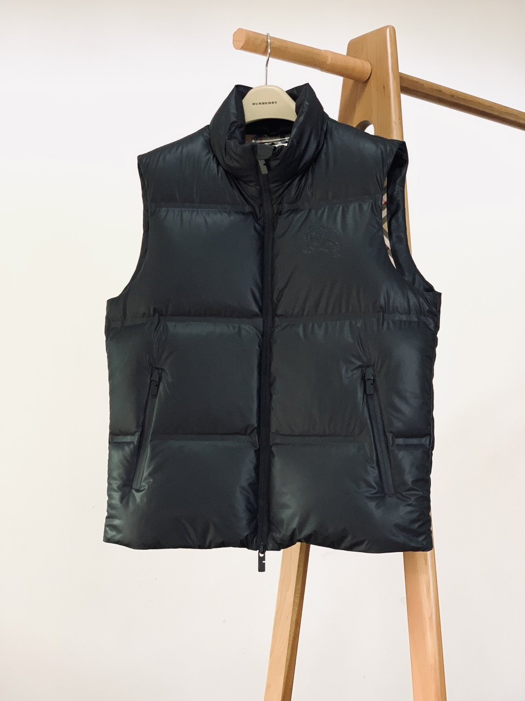 NO:691209,Burberry's 2025FW new autumn and winter leather down vest. The body is made of textured leather fabric, which is delicate to the touch, crisp and stylish; it is filled with 90 white duck down, which has excellent fluffiness and warmth, and can lock in temperature in cold winter without being bulky.  The brand's classic equestrian knight logo is embossed on the chest, and the embossed texture fully demonstrates the brand's recognition. It is unobtrusive but has a high-end aura. The all-black matte zipper is equipped with a customized metal puller, which opens and closes smoothly while echoing the style of the body. The elastic rib design of the cuffs fits the wrist to prevent wind and warmth; the waist is engraved with the brand  The character drawstring buckle allows you to freely adjust the silhouette, taking into account both practicality and design. The lining is made of iconic plaid fabric, which collides with the retro British style and modern down silhouette. The plaid details are exposed at the folds, and the sense of layering is instantly full. From the fabric selection to the turning and wiring, every aspect highlights the level of luxury craftsmanship.  ……………………………………………………………… SizeM-3XL,,burberry,burberry,down jacket,19860909Burberry 巴宝莉 2025FW秋冬新品 皮羽绒马甲背心.采用质感皮革面料打造衣身,触感细腻且挺括有型；内里填充90白鸭绒,蓬松度与保暖性双优,寒冬锁温不臃肿. 胸前压印品牌经典马术骑士徽标,浮雕质感尽显品牌辨识度,不张扬却自带高级气场.全黑哑光拉链搭配定制金属拉头,顺滑开合的同时与衣身风格呼应；袖口弹力罗纹设计,贴合腕部防风保暖；腰部配品牌刻字抽绳扣,可自由调节廓形,兼顾实用性与设计感.内衬采用标志性格纹面料,复古英伦风与现代羽绒廓形碰撞,翻折处露出格纹细节,层次感瞬间拉满.从面料选材到车工走线,每一处都彰显奢品工艺水准. …………………………………………………… SizeM-3XL,,burberry,burberry,down jacket,,Men's clothing