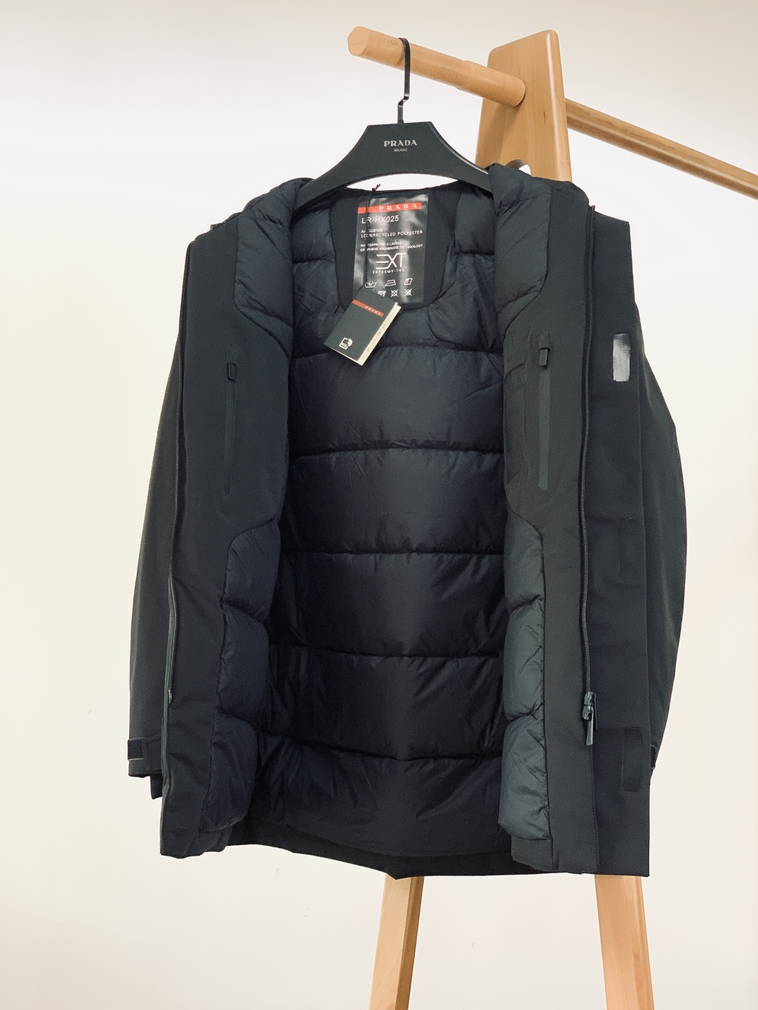 Prada 普拉达 2025FW秋冬新品中长款连帽羽绒服。采用100%再生聚酯纤维打造的三层防水面料，搭