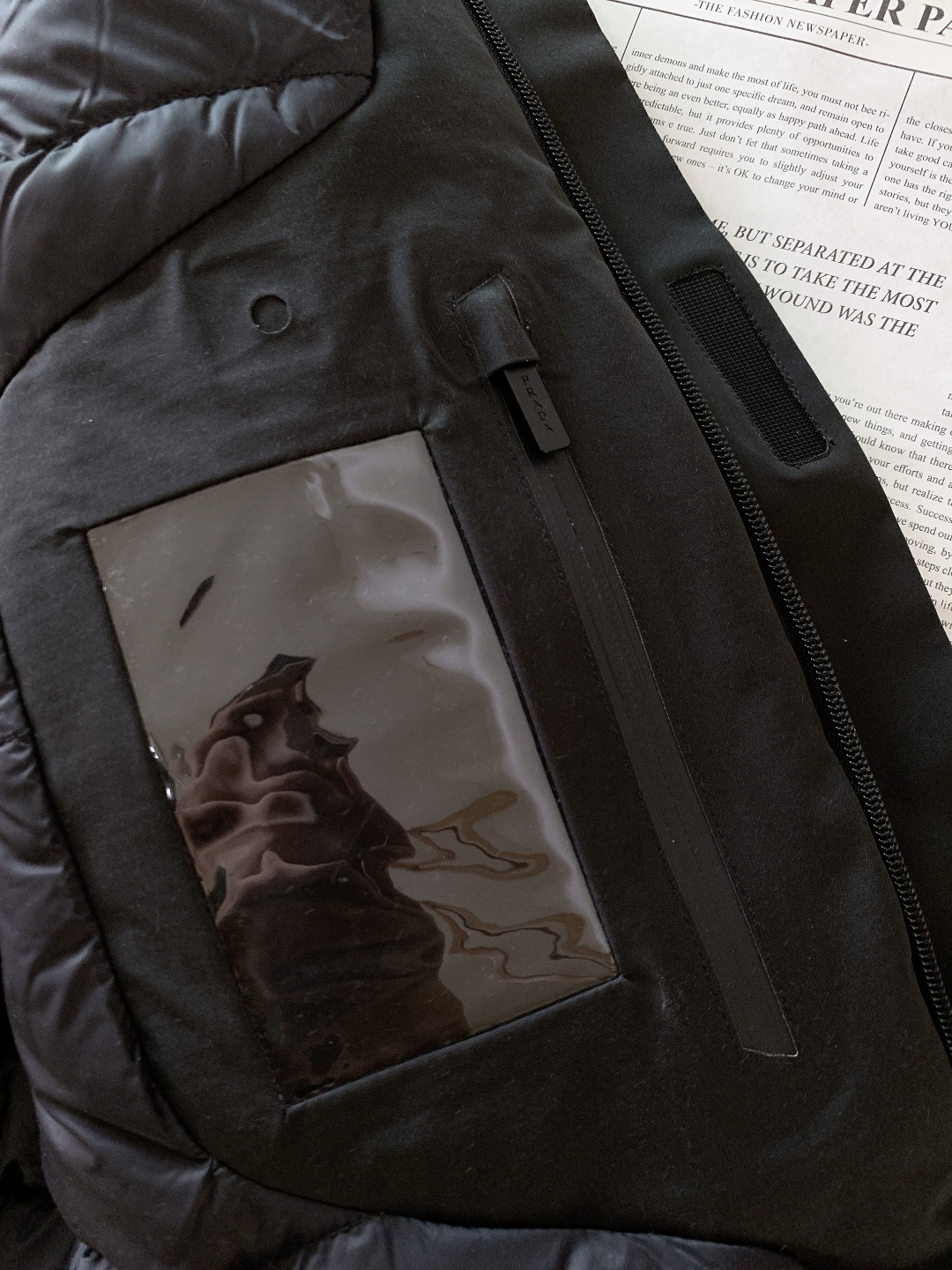 Prada 普拉达 2025FW秋冬新品中长款连帽羽绒服。采用100%再生聚酯纤维打造的三层防水面料，搭