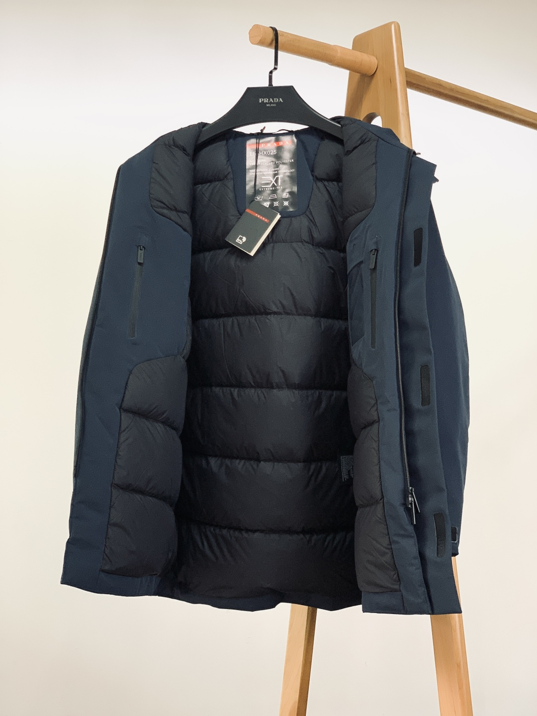 Prada 普拉达 2025FW秋冬新品中长款连帽羽绒服。采用100%再生聚酯纤维打造的三层防水面料，搭