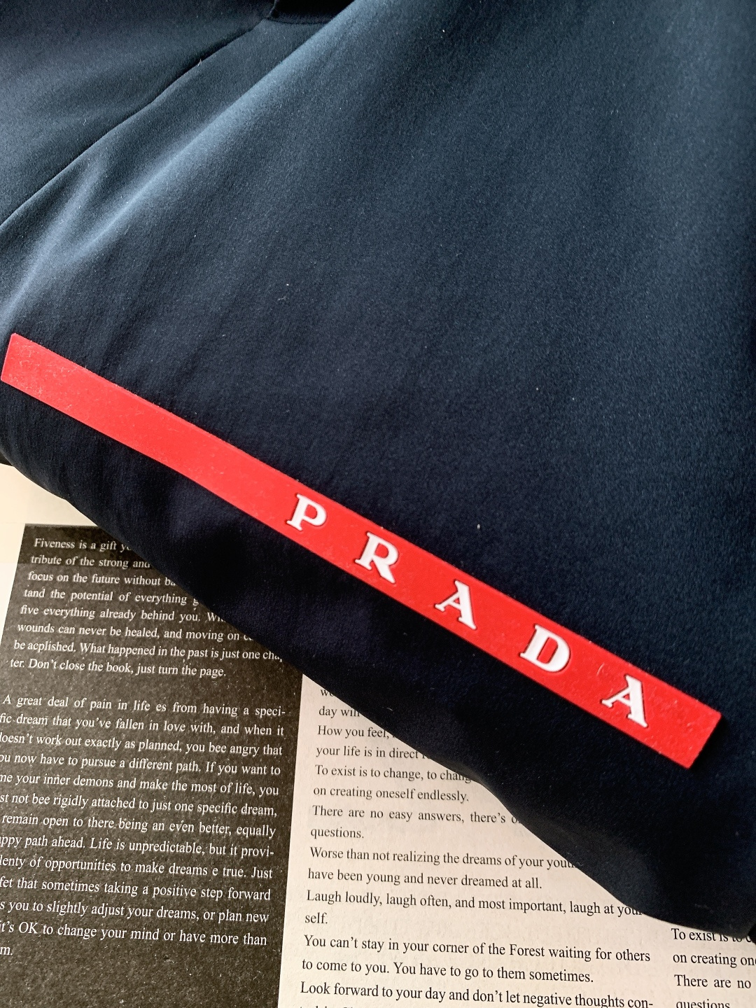 Prada 普拉达 2025FW秋冬新品中长款连帽羽绒服。采用100%再生聚酯纤维打造的三层防水面料，搭