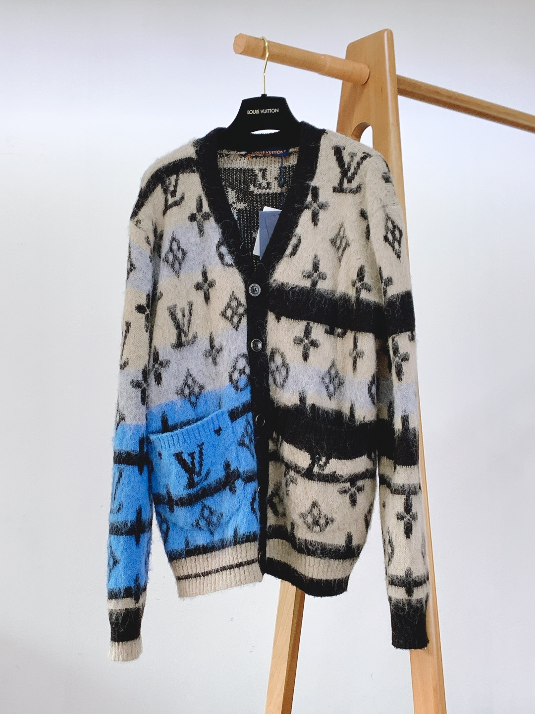 NO:692432,LouisVuitton Louis Vuitton's new 2025 FW autumn and winter product is a contrasting jacquard knitted cardigan. This knitted cardigan is made of mohair blended fabric. The natural velvet feel of mohair gives the body a fluffy and soft touch, with excellent warmth retention and light texture. The furry texture of the fabric is delicate, and it has a soft luster under the light and shadow, adding a high-end visual layer to the item.  The body of the garment is based on the iconic Monogram jacquard, with beige, black and bright blue contrasting stripes intertwined layer by layer, breaking the dullness of the classic presbyopia. The bright blue block is also integrated with large-size brand letter jacquard, becoming the visual focus;  The welt pocket on one side echoes the contrasting color design of the body, which is practical and stylish. The V-neck has clean lines and is matched with metal buttons engraved with letter logos. The black and gold color of the buttons contrasts with the velvet feel of the knitted fabric, and the details are full of luxury brand craftsmanship.  The cuffs are designed with ribbed edges. The ribbed texture is fine and long-lasting. It fits the wrist and contrasts with the loose fit of the body, making the overall lines more neat. The black hemming process on the collar and front is neat, clearly demarcating the visual boundaries of contrasting colors.  points, which enhances the sophistication of the item. The style adopts a loose oversize cut, which is very tolerant to the body shape. The dropped shoulder design modifies the shoulder line and creates a casual casual atmosphere. It is a luxurious item with both texture and style in autumn and winter.  …………………………………………… SizeS-XL,,louis vuitton,louis vuitton,versace,19860909LouisVuitton 路易威登 2025FW秋冬新品 撞色提花针织开衫.这款针织开衫选用马海毛混纺面料打造,马海毛的天然绒感让衣身呈现出蓬松柔软的触感,兼具出色的保暖性与轻盈质感；面料的毛茸肌理细腻,光影下泛着柔和的光泽,为单品增添了高级的视觉层次. 衣身以标志性的Monogram提花为基底,米色、黑色与亮蓝色的撞色条纹层层交织,打破了经典老花的沉闷感,亮蓝色块面还融入了大尺寸品牌字母提花,成为视觉焦点；单侧的贴边口袋与衣身撞色设计呼应,实用又不失造型感.V领线条利落,搭配刻有字母标识的金属纽扣,纽扣的黑金配色与针织面料的绒感形成材质对比,细节处尽显奢牌工艺. 袖口采用罗纹收边设计,罗纹纹理细密且弹性持久,贴合手腕的同时与衣身的宽松版型形成对比,让整体线条更显利落；领口与前襟的黑色包边工艺工整,将撞色的视觉边界清晰划分,提升了单品的精致度.版型采用宽松的Oversize剪裁,对身形包容度极高,落肩设计修饰肩部线条,营造随性的休闲氛围.是秋冬季节兼具质感与造型感的奢雅单品. …………………………………………………… SizeS-XL,,louis vuitton,louis vuitton,versace,,Men's clothing