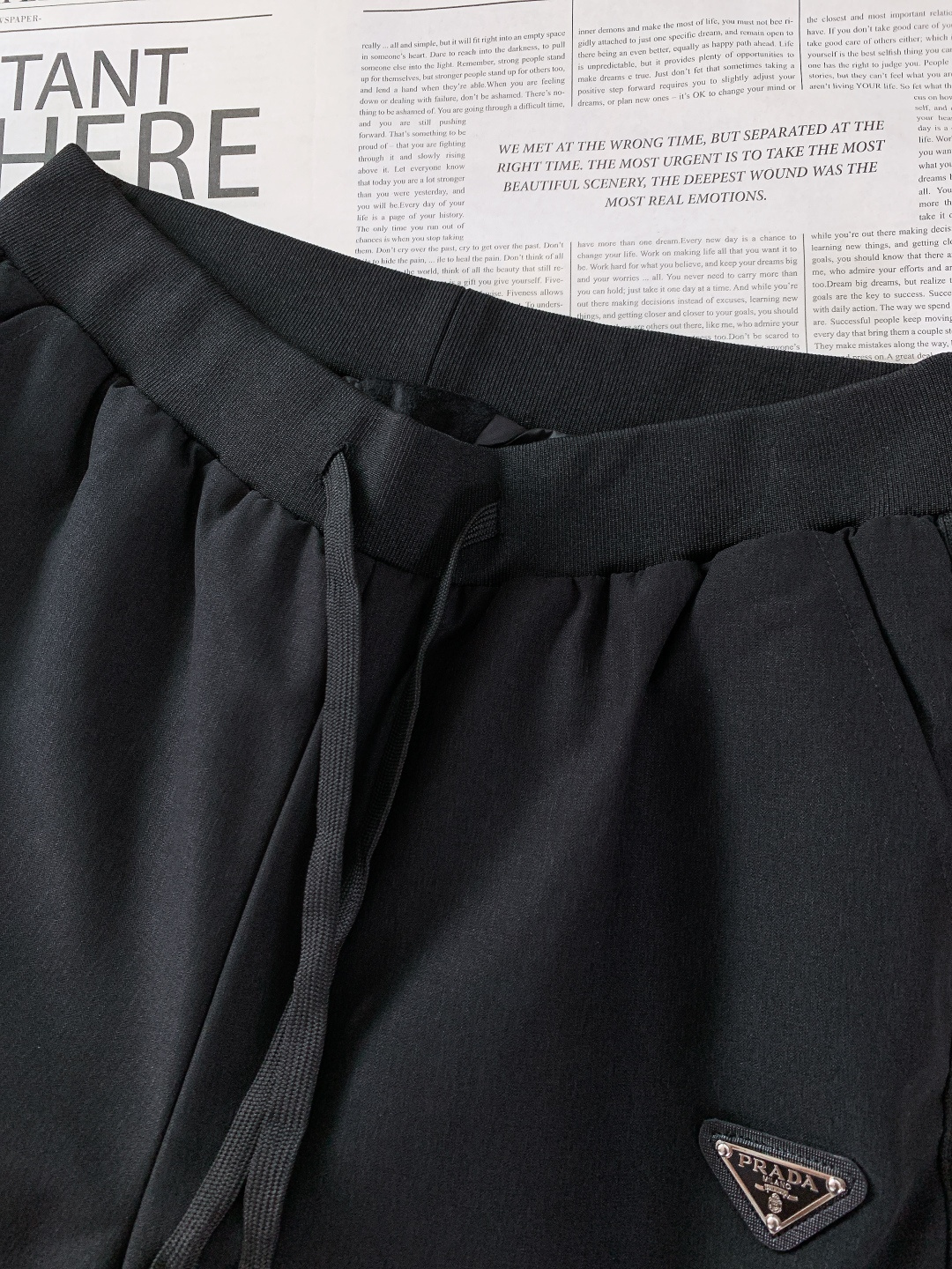 Prada 普拉达 2025FW秋冬新品休闲织带羽绒裤，经典三角徽标彰显品牌辨识度，侧边白条纹勾勒利落线