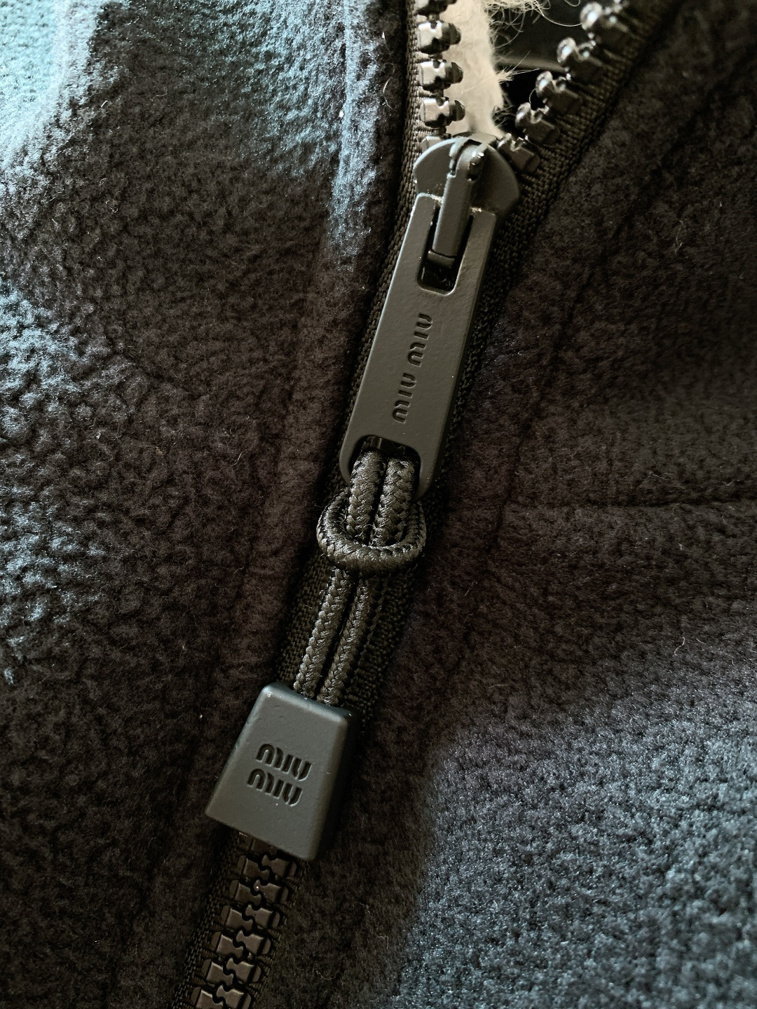 Miumiu 缪缪 2025FW秋冬新品摇粒绒羽绒服，外层深蓝抓绒内里高绒量羽绒，轻盈又保暖。灰色羊羔毛