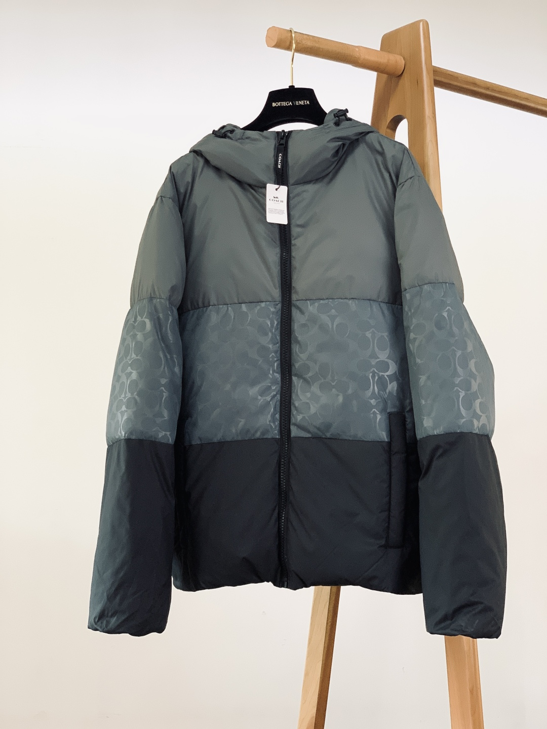 Coach 蔻驰 新款黑灰渐变色男士羽绒服拼色经典连帽外套！！！这是这款羽绒服最引人注目的设计。它采用了