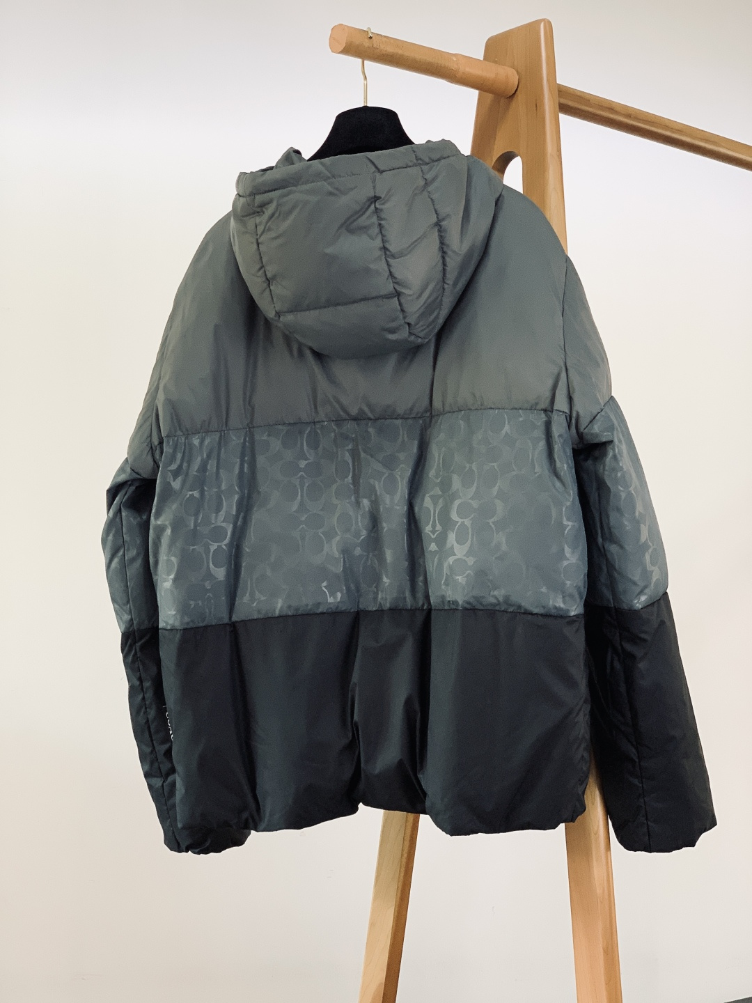 Coach 蔻驰 新款黑灰渐变色男士羽绒服拼色经典连帽外套！！！这是这款羽绒服最引人注目的设计。它采用了