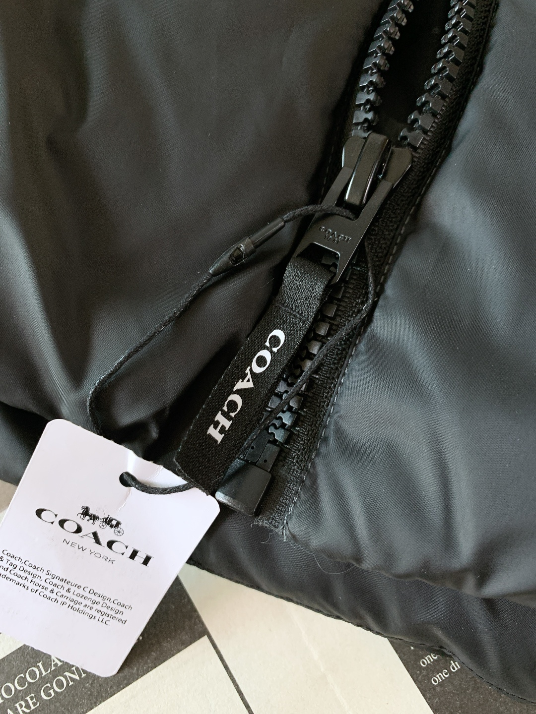 Coach 蔻驰 新款黑灰渐变色男士羽绒服拼色经典连帽外套！！！这是这款羽绒服最引人注目的设计。它采用了