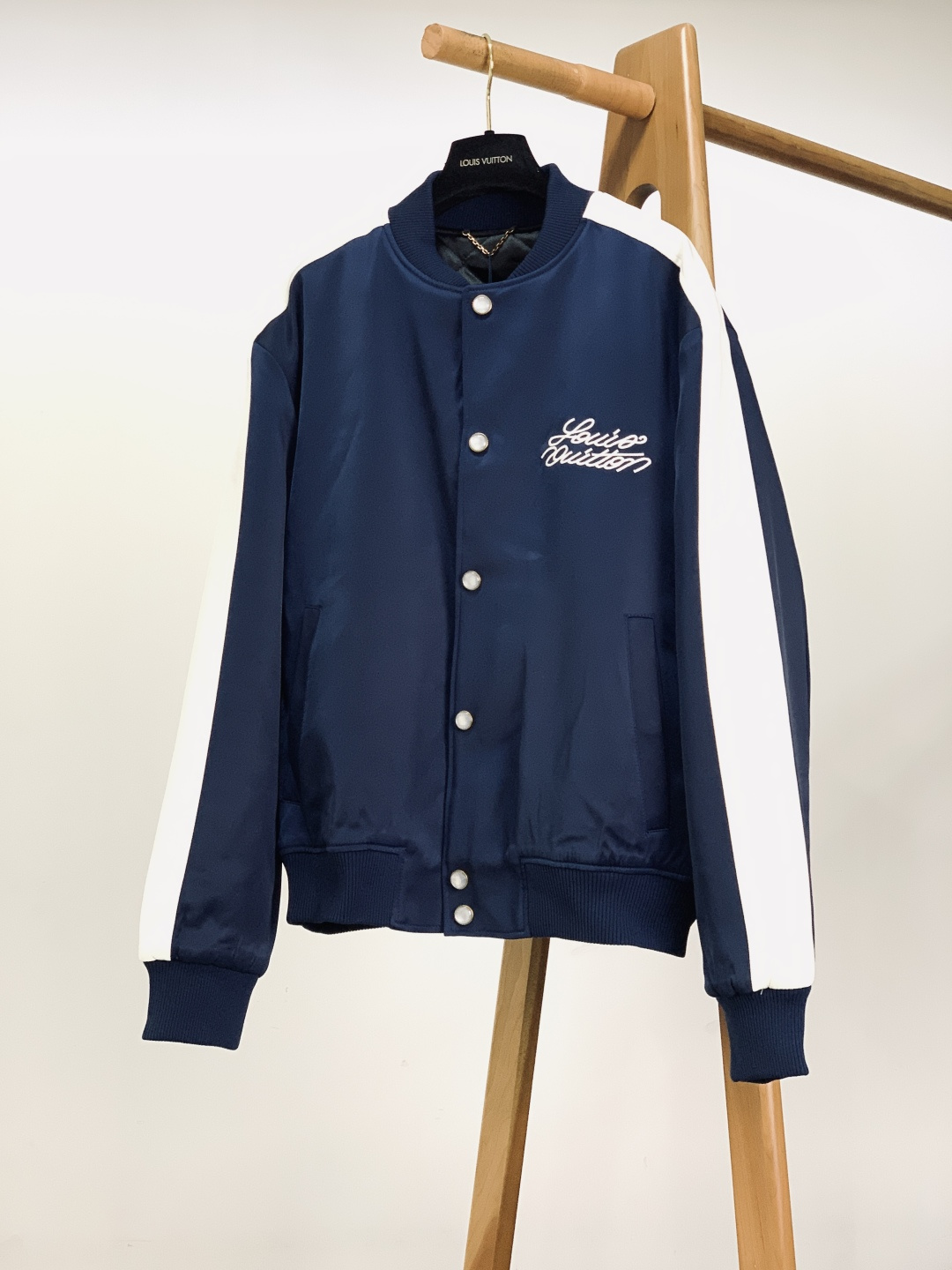 NO:726129,Support the new Louis Vuitton 2026 SS early spring new product Year of the Horse limited edition baseball uniform after the new year. It is made of high-density heavyweight polyester fiber satin fabric, with a delicate glossy surface, smooth and drapey touch, and not easy to wrinkle. It has a crisp silhouette and a comfortable wearing experience. The interior is designed with rhombus quilting and quilting, which ensures warmth while avoiding bloat, and is suitable for wearing needs in various scenes in autumn and winter.  The milky white resin buttons at the placket are printed with the brand's logo, and are paired with aged gold edging, which has a warm texture and full recognition; the metal buttons at the cuffs and side seams are embossed with the classic logo, and the details highlight the brand's ingenuity. The front uses three-dimensional embroidery technology to present the handwritten brand logo, with smooth and full lines; the back uses high-precision embroidery to restore the 'horse galloping in the forest' pattern, which combines the elements of the Year of the Horse zodiac and the iconic Monogram dark pattern, which is rich in layers and highly collectible.  The contrasting white edge splicing design with ribbed stand-up collar and cuffs combines retro sportiness with modern light luxury. The ribbing on the hem and cuffs has moderate elasticity, fits the body shape and is not easy to deform.  This baseball uniform perfectly balances LV's luxury genes with the casual attributes of American baseball uniforms. Whether it is paired with a turtleneck sweater and jeans for a daily commuting look, or worn with a sweater and sweatpants to create a street trend, it can be easily controlled. The combination of dark blue background and white contrasting colors is classic and versatile, suitable for business and leisure, weekend outings, light socializing and other scenarios. It is an iconic item that shows personality and taste in the Year of the Horse. Size 46, length 68, bust 126, shoulder width 55, sleeve length 66  Size 48, length 70, chest 130, shoulder width 56, sleeve length 67, size 50, length 72, chest 134, shoulder width 57, sleeve length 68, size 52, length 74, chest 138, shoulder width 58, sleeve length 69...19860909支持年后 LouisVuitton 路易威登 2026SS早春新品 马年限定款棒球服.选用高密重磅聚酯纤维缎面面料,表面自带细腻光泽感,触感顺滑垂挺且不易起皱,兼具挺括廓形与舒适穿着体验.内里采用菱格绗缝夹棉设计,在保证保暖性的同时,也避免了臃肿感,适配秋冬季节多场景穿着需求. 门襟处的乳白色树脂纽扣印有品牌标识字样,搭配做旧金色包边,质感温润且辨识度拉满；袖口与侧缝处的金属纽扣则压印经典标识,细节处彰显品牌匠心. 正面采用立体凸绣工艺呈现手写体品牌标识,线条流畅饱满；背面以高精密刺绣还原“骏马奔林”图案,融合了马年生肖元素与标志性的Monogram暗纹,层次丰富且极具收藏价值. 撞色白边拼接设计搭配罗纹立领与袖口,兼顾复古运动感与现代轻奢气质,下摆与袖口的罗纹弹力适中,贴合身形且不易变形. 这款棒球服完美平衡了LV的奢华基因与美式棒球服的休闲属性,无论是搭配高领针织衫与牛仔裤打造日常通勤造型,还是内搭卫衣与运动裤营造街头潮流感,都能轻松驾驭.深蓝底色与白色撞色的组合经典百搭,适配商务休闲、周末出游、轻社交等多场景,是马年彰显个性与品味的标志性单品. 46码衣长68 胸围126 肩宽55 袖长66 48码衣长70 胸围130 肩宽56 袖长67 50码衣长72 胸围134 肩宽57 袖长68 52码衣长74 胸围138 肩宽58 袖长69 …………………………………………………… Size46-52,,louis vuitton,louis vuitton,louis vuitton,hoodie,sweatshirts,jeans,,Men's clothing