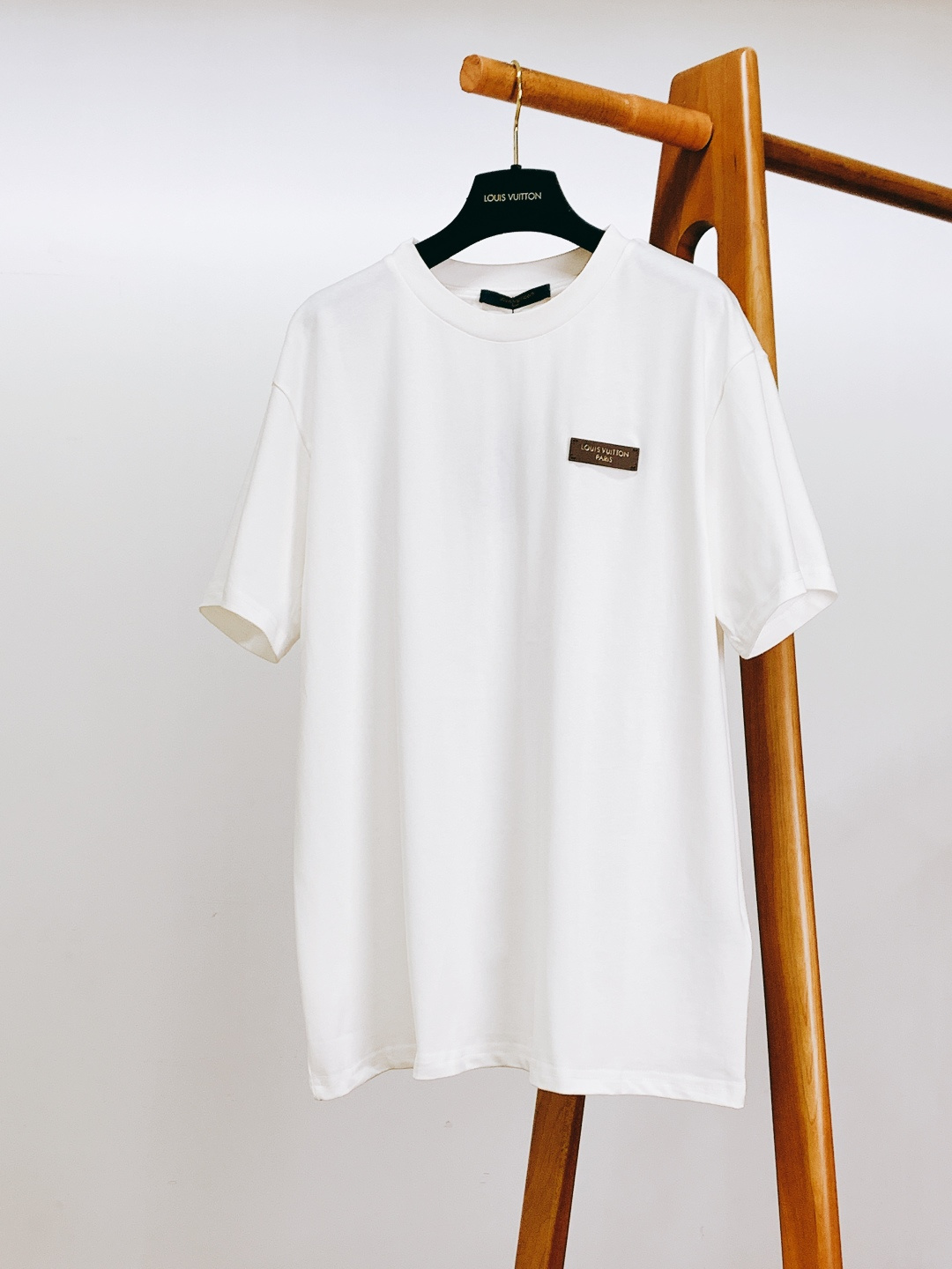 NO:726144,Support the new Louis Vuitton 2026 SS early spring new product badge logo short sleeves after the year. Made of g-heavy double-ply Xinjiang long-staple cotton fabric, which has been pre-shrunk. It feels soft and skin-friendly and is not easy to deform after long-term washing. The fabric has a delicate texture, has both stiffness and breathability, and the upper body will not be sweaty. It is a quality basic style that can be matched with all seasons.  The left chest is embedded with a dark brown matte metal plate, with gold-engraved letters and logos, and reinforced edge rivets, giving it a low-key luxury feel. The neckline of the back is decorated with a navy-blue orange woven label, and is printed with the brand's classic slogan 'MARQUE L.VUITTON DEPOSEE', which is full of retro style and has become an exclusive logo for attention to detail.  The neckline adopts a double-needle hemming rib design, which has moderate elasticity and is washable and non-deformable; the overlocking process of the cuffs and hem is smooth and fine, demonstrating LV's ultimate pursuit of details.  This T-shirt is based on a minimalist silhouette, embellished with iconic badges and woven labels, perfectly balancing the brand's luxury genes with practicality for daily wear. Whether worn alone to create a cleanfit minimalist style, or layered with a sweater/shirt to create a layered look, it can be easily controlled. The classic white color is versatile and suitable for commuting, leisure, light socializing and other scenarios. It is an indispensable 'magic oil' item in the wardrobe. …………………………………………………… SizeS-XL, Louis  vuitton,louis vuitton,louis vuitton,hoodie,sweatshirts,shirts,T-shirt,tees,t-shirt,19860909支持年后 LouisVuitton 路易威登 2026SS早春新品 徽章标识短袖.采用g重磅双股新疆长绒棉面料,经过预缩水处理,触感软糯亲肤且久洗不易变形.面料自带细腻肌理感,兼具挺括性与透气性,上身不闷汗,是四季百搭的品质基础款. 左胸嵌入深棕色哑光金属牌,金色刻印字母标识字样,边缘铆钉加固,低调中透出奢华质感. 后背领口处点缀藏青底橙字织唛,印有品牌经典标语“MARQUE L.VUITTON DEPOSEE”,复古风格拉满,成为细节控的专属标识. 领口采用双针包边罗纹设计,弹力适中且耐洗不变形；袖口与下摆的锁边工艺平整细密,彰显LV对细节的极致追求. 这款T恤以极简版型为基底,通过标志性徽章与织唛点缀,完美平衡了品牌的奢华基因与日常穿搭的实用性.无论是单穿打造Cleanfit极简风,还是内搭卫衣/衬衫营造层次感,都能轻松驾驭.经典白色百搭不挑人,适配通勤、休闲、轻社交等多场景,是衣橱里不可或缺的“万金油”单品. …………………………………………………… SizeS-XL,,louis vuitton,louis vuitton,louis vuitton,hoodie,sweatshirts,shirts,T-shirt,tees，t-shirt,,Men's clothing