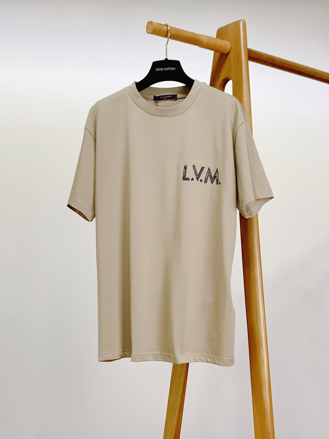 NO:726152,Support the new Louis Vuitton 2026 SS early spring new product embroidered letter T-shirt. It is made of 240g heavyweight double-ply long-staple cotton fabric, which has been pre-shrunk. It feels soft and boney, has both breathability and stiffness, and is not easy to deform and yellow after long-term washing. The light khaki background comes with a gentle filter, suitable for all seasons.  The 'L.V.M.' letter logo is embroidered with thick navy blue thread on the left chest, and the lines have a handwritten texture, which is full of layers and full of recognition; the entire brand information embroidery on the back combines the handwriting style and the brand's founding year '1854', which has both an artistic and retro feel. The navy background orange woven label at the back neckline is printed with the brand's classic slogan 'MARQUE L.VUITTON'  'DEPOSEE' continues the brand's design language of retro details. The neckline adopts double-needle hemming ribbing, which is moderately elastic and resistant to washing and does not deform; the overlocking process of the cuffs and hem is smooth and fine, and the stitching is even, highlighting the brand's ultimate pursuit of details.  This T-shirt is based on a minimalist silhouette, embellished with handwritten embroidery and retro woven labels, perfectly balancing the brand's luxury genes and street trend attributes. The light khaki color is versatile and easy to wear, and can be worn alone to create a Cleanfit minimalist style. Paired with a sweater or shirt to create a rich sense of layering, it is suitable for commuting, leisure, light socializing and other scenes. It is a versatile 'hard currency' in the wardrobe. ……………………………………………… SizeS-XL, louis vuitton, louis  vuitton,hoodie,sweatshirts,shirts,tees,t-shirt,19860909支持年后 LouisVuitton 路易威登 2026SS早春新品 绣花字母T恤.采用240g重磅双股长绒棉面料,经过预缩水处理,触感软糯有骨感,兼具透气性与挺括度,久洗不易变形、发黄.浅卡其底色自带温柔滤镜,适配四季穿搭场景. 左胸以藏青粗线绣出“L.V.M.”字母标识,线条带有手写感纹理,层次饱满且辨识度拉满；后背整幅品牌信息刺绣,融合手写体风格与品牌创立年份“1854”,艺术感与复古感兼具. 后背领口处的藏青底橙字织唛,印有品牌经典标语“MARQUE L.VUITTON DEPOSEE”,延续了品牌复古细节的设计语言. 领口采用双针包边罗纹,弹力适中且耐洗不变形；袖口与下摆的锁边工艺平整细密,针脚均匀,彰显品牌对细节的极致追求. 这款T恤以极简版型为基底,通过手写感刺绣与复古织唛点缀,完美平衡了品牌的奢华基因与街头潮流属性.浅卡其色百搭不挑人,单穿可打造Cleanfit极简风,内搭卫衣或衬衫能营造丰富层次感,适配通勤、休闲、轻社交等多场景,是衣橱里的百搭“硬通货”. …………………………………………………… SizeS-XL,,louis vuitton,louis vuitton,hoodie,sweatshirts,shirts,tees，t-shirt,,Men's clothing
