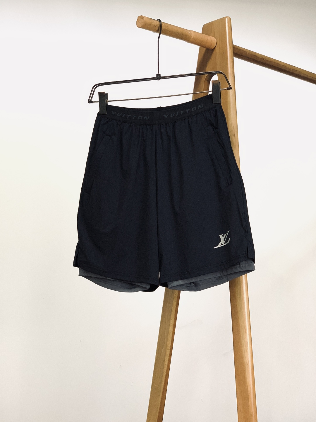 NO:726136,LouisVuitton double-layer sports shorts are supported after the New Year. They are made of high-density quick-drying nylon fabric, which is light and smooth to the touch. It has excellent breathability and quick-drying properties and does not stick to the body after sweating. The outer layer is wear-resistant and wrinkle-resistant, and the inner layer is skin-friendly and breathable. The double-layer structure takes into account practicality and comfort, adapting to the needs of wearing in many scenes in summer.  The wide elastic waistband uses embossing technology to display the word 'VUITTON'. It has moderate elasticity and fits the waist and abdomen for long-term wear. There are invisible zipper pockets on both sides, and the anti-theft design takes into account practicality. The metal zipper puller is engraved with the brand logo, and the details highlight the brand texture.  The double-layer contrasting trouser legs, with a contrasting design of black outer layer and dark gray inner layer, enrich the visual hierarchy; the trouser legs adopt double-thread seaming technology, which is flat and wear-resistant and difficult to open; the side seams are also printed with reflective logos to improve the safety of traveling at night.  These shorts are based on sports and leisure styles, with simple logos and contrasting details, perfectly balancing the brand's luxury genes and daily practicality. The classic black is versatile and easy to match. It can be worn with a T-shirt to create a refreshing summer look, or with tights to create an outdoor functional style. It is suitable for commuting, fitness, travel and other scenes. It is an essential item for the summer wardrobe. ……………………………………………… Size46-52, louis vuitton, louis  vuitton,shorts,tees,t-shirt,19860909支持年后 LouisVuitton 路易威登 双层运动短裤 采用高密速干锦纶面料,触感轻薄顺滑,具备优异的透气与速干性能,出汗后不粘身.外层耐磨抗皱,内层亲肤透气,双层结构兼顾实用性与舒适度,适配夏季多场景穿着需求. 宽版弹力腰头采用压印工艺呈现“VUITTON”字样,弹力适中且贴合腰腹,久穿不勒. 两侧设有隐形拉链口袋,防盗设计兼顾实用性,金属拉链头刻有品牌标识,细节处彰显品牌质感. 双层撞色裤脚,外层黑色与内层深灰的撞色设计,丰富视觉层次；裤脚采用双线锁边工艺,平整耐磨不易开线；侧缝处还印有反光标识,提升夜间出行安全性. 这款短裤以运动休闲版型为基底,通过简约标识与撞色细节,完美平衡了品牌的奢华基因与日常实用性.经典黑色百搭不挑人,既能搭配T恤打造清爽夏日造型,也能内搭紧身裤营造户外机能风,适配通勤、健身、出游等多场景,是夏季衣橱的刚需单品. …………………………………………………… Size46-52,,louis vuitton,louis vuitton,shorts,tees，t-shirt,,Men's clothing