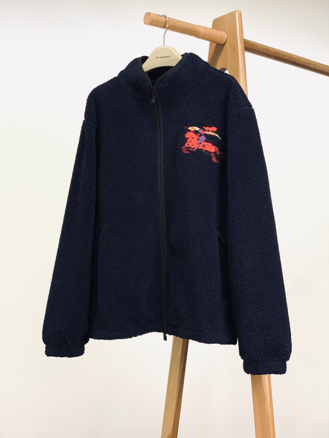 NO:726114,Support the new Burberry 2026 SS early spring new product after the new year, the embroidered fleece jacket. It is made of 50% wool polyester fiber cashmere blended fleece fabric, which is soft and fluffy to the touch. It has the warmth of wool and the skin-friendly feel of cashmere. The upper body is light and warm without pressing down. The interior is equipped with a breathable mesh lining, which makes it not stuffy and sweaty when worn, and is suitable for wearing needs in various autumn and winter scenes.  Three-dimensional embroidery is used on the front left chest and back to present the brand's iconic equestrian knight pattern. The contrasting colors of red, blue and gold are full of layers, and the 'PRORSUM' slogan webbing is full of details, which is both recognizable and artistic. The stand-up collar is equipped with a double-open zipper puller design, which can freely adjust the opening and closing of the collar; there is a red and gold contrasting drawstring at the hem, and a black buckle engraved with the brand logo can tighten the hem, preventing wind and warmth.  The collar and zipper edges are made of black hemming technology, which is wear-resistant and enhances the visual hierarchy; the fleece edges on the cuffs and hem naturally fit the body shape, and the hemming process is smooth and fine, highlighting the brand's ultimate pursuit of details.  This jacket is made of retro fleece material, with iconic equestrian knight embroidery and functional details, perfectly balancing the brand's British genes and outdoor leisure attributes. The navy blue background is versatile and easy to match. It can be paired with a turtleneck sweater and jeans to create a daily commuting look, or it can be worn with a sweatshirt and overalls to create a relaxed feeling on the street. It is suitable for many scenes such as autumn and winter commuting, outdoor outings, light socializing, etc. It is a must-have item for autumn and winter to show your taste. Size S, length 69, bust 114  Shoulder width 50, size M, length 70, chest 118, shoulder width 51, length 71, size L, chest 122, shoulder width 52, length 72, size XL, chest 126, length 53,19860909支持年后 Burberry 巴宝莉 2026SS早春新品 抓绒绣花外套.采用50羊毛聚酯纤维羊绒混纺抓绒面料,触感软糯蓬松,兼具羊毛的保暖性与羊绒的亲肤感,上身轻暖不压身.内里搭配透气网眼衬里,穿着不闷汗,适配秋冬多场景穿着需求. 正面左胸与后背均采用立体刺绣工艺呈现品牌标志性马术骑士图案,红、蓝、金三色撞色层次饱满,“PRORSUM”标语织带细节拉满,辨识度与艺术感兼具. 立领搭配双开拉链头设计,可自由调节领口开合度；下摆处设有红金撞色抽绳,刻有品牌标识的黑色卡扣可收紧衣摆,防风保暖. 领口与拉链边缘采用黑色包边工艺,耐磨且强化视觉层次；袖口与衣摆的抓绒收边自然贴合身形,锁边工艺平整细密,彰显品牌对细节的极致追求. 这款外套以复古抓绒材质为基底,通过标志性马术骑士刺绣与机能细节,完美平衡了品牌的英伦基因与户外休闲属性.藏青底色百搭不挑人,既能搭配高领针织衫与牛仔裤打造日常通勤造型,也能内搭卫衣与工装裤营造街头松弛感,适配秋冬通勤、户外出游、轻社交等多场景,是彰显品味的秋冬刚需单品. S码衣长69 胸围114 肩宽50 M码衣长70 胸围118 肩宽51 L码衣长71 胸围122 肩宽52 XL码衣长72 胸围126 肩宽53 …………………………………………………… SizeS-XL,,burberry,burberry,hoodie,sweatshirts,jeans,jackets & coats,,Men's clothing