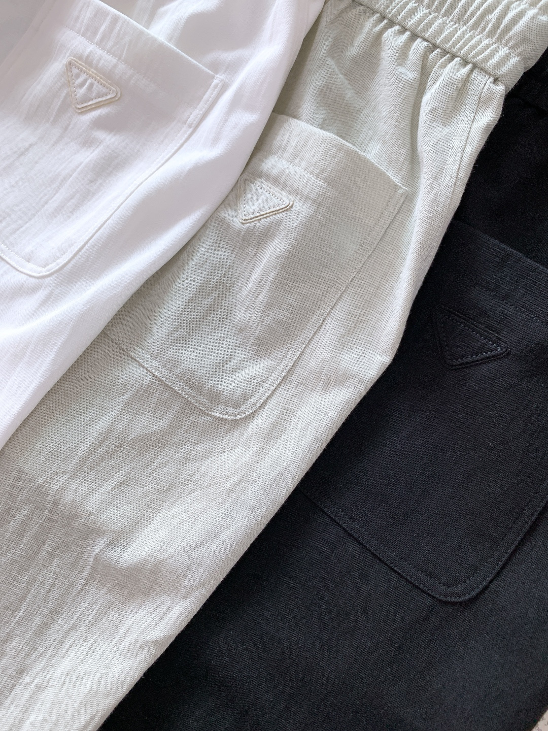Prada 普拉达 2026SS早春新品三角标休闲裤。采用高支棉混纺面料，布面呈现细腻的肌理感，触感轻薄