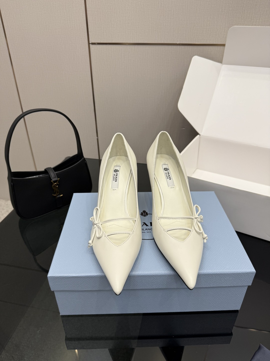 NO:694568,(Add 10 if you need an airplane box) Prada/Prada 26WF early spring new pointed-toe high-heeled shoes. When the bright orange show sunlight penetrates the steel window, this pair of catwalk high-heeled shoes comes out of the light. It uses 'constructed body' to deconstruct the established definition of elegance. The pointed-toe design is more than just an ingenious idea to lengthen the leg shape. The back strap and bow details find a balance between hardness and softness. It breaks away from the inertial perception of 'comfort is luxury' but uses the skin-friendly texture of sheepskin lining.  Realize the dual freedom of mind and body. From commuting suits to dinner dresses, it seamlessly adapts to multiple scenes, allowing women to switch between competence and femininity. Every time you step on the foot, the whisper of the metal logo and the ground is the resonance of pioneering design and daily functions. It is also the undefined confidence and edge of contemporary women. The fabric is made of original customized lambskin, and the lining of the toes is made of sheepskin. The genuine leather outsole imported from Italy  size35-39 (customized 40/41), high heels, prada, prada, high heels, skirts, business suit, sheepskin, Leather soles19860909（要飞机盒加10） Prada/普拉达26WF早春新品尖头高跟鞋 当亮橙色秀场的阳光穿透钢窗 这双走秀高跟鞋踏光而来 以“构筑之躯” 解构优雅的既定定义 尖头设计不止是拉长腿型的巧思 后饰带与蝴蝶结细节在刚柔之间找到平衡. 它挣脱了“舒适即奢侈”的惯性认知 却以羊皮内里的亲肤质感 实现心灵与身体的双重自由. 从通勤西装到晚宴礼裙 它无缝适配多元场景 让女性在干练与柔美中自主切换. 每一次落脚都是金属徽标与地面的轻语 是先锋设计与日常功能的共鸣 更是当代女性不被定义的底气与锋芒. 面料采用原版定制小羊皮 内里踮脚均为羊皮 意大利进口真皮大底 size35-39（40/41定制）,高跟鞋单鞋,prada,prada,high heels,skirts,business suit,sheepskin,Leather soles,Women's Shoes