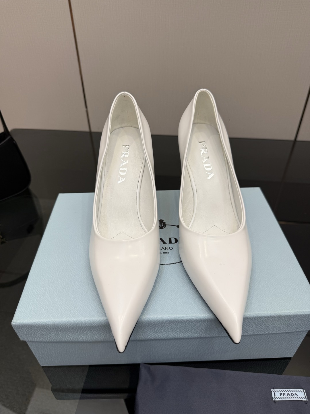 NO:757794,Prada/Prada 26WF early spring new pointed-toe high-heeled shoes. When the bright orange show sunlight penetrates the steel window, this pair of catwalk high-heeled shoes comes out of the light. It uses 'constructed body' to deconstruct the established definition of elegance. The pointed-toe design not only lengthens the leg shape, it breaks away from the inertial perception of 'comfort is luxury', but uses the skin-friendly texture of the sheepskin lining to achieve dual freedom of mind and body. From commuter suits to dinner dresses, it seamlessly adapts to multiple scenes.  It allows women to switch between being capable and feminine. Every time they set foot, there is a whisper between the metal logo and the ground. It is the resonance of avant-garde design and daily functions, and it is also the undefined confidence and edge of contemporary women. The fabric is made of original customized open-edge beaded cowhide. The lining and toes are all sheepskin. Italian imported leather outsole. Heel height 8.5cm, size 35-39 (customized for 40/41), single shoes, prada, prada, high heels, skirts, business  suit,cowhide,sheepskin,leather soles19860909Prada/普拉达26WF早春新品尖头高跟鞋 当亮橙色秀场的阳光穿透钢窗 这双走秀高跟鞋踏光而来 以“构筑之躯” 解构优雅的既定定义 尖头设计不止是拉长腿型 它挣脱了“舒适即奢侈”的惯性认知 却以羊皮内里的亲肤质感 实现心灵与身体的双重自由. 从通勤西装到晚宴礼裙 它无缝适配多元场景 让女性在干练与柔美中自主切换. 每一次落脚都是金属徽标与地面的轻语 是先锋设计与日常功能的共鸣 更是当代女性不被定义的底气与锋芒. 面料采用原版定制开边珠牛皮 内里踮脚均为羊皮 意大利进口真皮大底 跟高8.5cm size35-39（40/41定制）,单鞋,prada,prada,high heels,skirts,business suit,cowhide,sheepskin,Leather soles,Women's Shoes