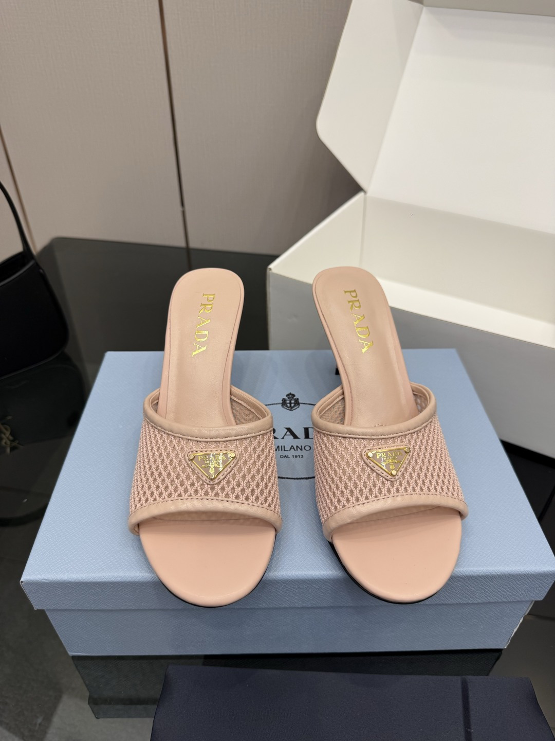 NO:781423,Prada/Prada 26WF spring and summer new product triangle logo mesh high-heeled slippers use lightweight mesh to reshape the modern silhouette of high-heeled slippers. The iconic enamel-coated triangle metal logo is eye-catching and instantly lights up the minimalist upper, showing the brand's neat style. Breathable mesh material runs through spring and summer, saying goodbye to the sultry constraints. The steps are refreshing and comfortable. The high heels elongate the proportion of the legs while taking into account stability, sexy and advanced. The slingback design is easy to put on and take off.  Seamless connection between commuting, dating and vacation. Minimalist black, beige and other classic colors are suitable for a variety of outfits. It is casual and fashionable with jeans or with a dress to show your femininity. High-heeled slippers can also be easily matched with a relaxed style, becoming a summer item in the wardrobe. The fabric is made of original customized materials. The lining of the toes is sheepskin. Italian imported leather outsole size 35-39 (customized 40/41), high-heeled slippers, prada, prada, high  heels,slippers,skirts,jeans,sheepskin,Leather soles19860909Prada/普拉达26WF春夏新品三角标 网面高跟拖鞋 以轻盈网面重塑高跟拖鞋的现代轮廓. 标志性涂珐琅三角金属徽标醒目坐镇 瞬间点亮极简鞋面 尽显品牌利落风骨 . 透气网眼材质贯穿春夏 告别闷热束缚 步履间尽是清爽自在. 高跟拉长腿部比例的同时兼顾稳当 性感又高级 露跟设计穿脱便捷 无缝衔接通勤、约会与度假多场景. 极简黑、米等经典色适配多元穿搭 配牛仔裤随性时髦 搭连衣裙尽显女人味. 让高跟拖鞋也能轻松拿捏松弛格调, 成为衣橱里的夏日气场单品. 面料采用原版定制材质 内里踮脚均为羊皮 意大利进口真皮大底 size35-39（40/41定制）,高跟鞋拖鞋,prada,prada,high heels,slippers,skirts,jeans,sheepskin,Leather soles,Women's Shoes