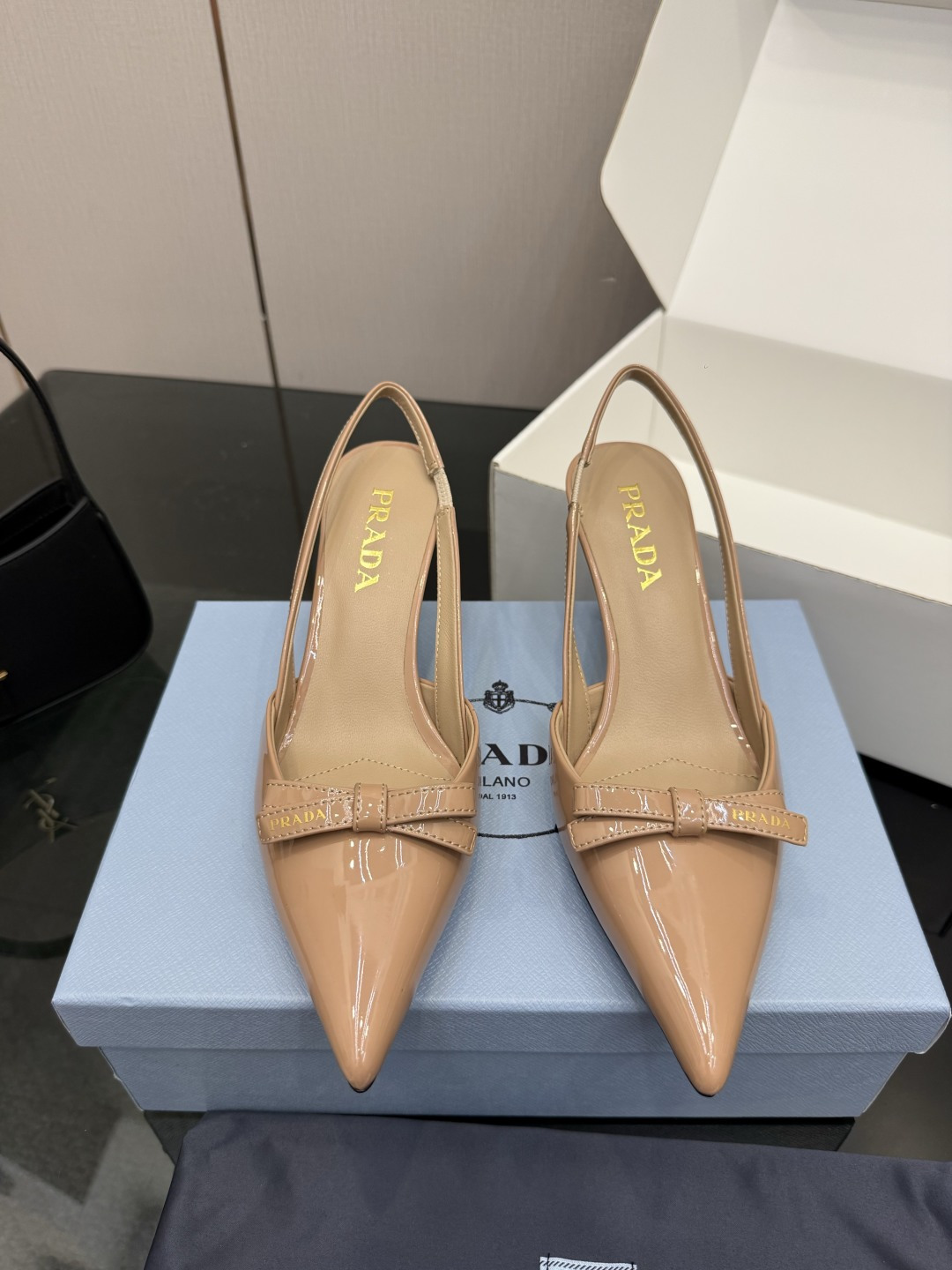 NO:784811,Top version of Prada/Prada 26WF spring and summer new product pointed toe empty back sandals and high heels. When the bright orange show sunlight penetrates the steel window, this pair of catwalk high heels comes out of the light. It deconstructs the established definition of elegance with 'constructed body'. The pointed toe design is not only an ingenious idea to lengthen the leg shape. The back strap and bow details find a balance between hardness and softness. It breaks away from the inertial perception of 'comfort is luxury' but uses the skin-friendly texture of sheepskin lining.  Realize the dual freedom of mind and body. From commuting suits to dinner dresses, it seamlessly adapts to multiple scenes, allowing women to switch between competence and femininity. Every time you step on the foot, the whisper of the metal logo and the ground is the resonance of pioneering design and daily functions. It is also the undefined confidence and edge of contemporary women. The fabric is made of original customized lambskin, and the lining of the toes is made of sheepskin. The genuine leather outsole imported from Italy  size35-39 (customized 40/41), high heels and sandals, prada, prada, sandals, high heels, skirts, business suit, sheepskin, Leather soles19860909顶版 Prada/普拉达26WF春夏新品尖头 后空凉鞋高跟鞋 当亮橙色秀场的阳光穿透钢窗 这双走秀高跟鞋踏光而来 以“构筑之躯” 解构优雅的既定定义 尖头设计不止是拉长腿型的巧思 后饰带与蝴蝶结细节在刚柔之间找到平衡. 它挣脱了“舒适即奢侈”的惯性认知 却以羊皮内里的亲肤质感 实现心灵与身体的双重自由. 从通勤西装到晚宴礼裙 它无缝适配多元场景 让女性在干练与柔美中自主切换. 每一次落脚都是金属徽标与地面的轻语 是先锋设计与日常功能的共鸣 更是当代女性不被定义的底气与锋芒. 面料采用原版定制小羊皮 内里踮脚均为羊皮 意大利进口真皮大底 size35-39（40/41定制）,高跟鞋凉鞋,prada,prada,sandals,high heels,skirts,business suit,sheepskin,Leather soles,Women's Shoes