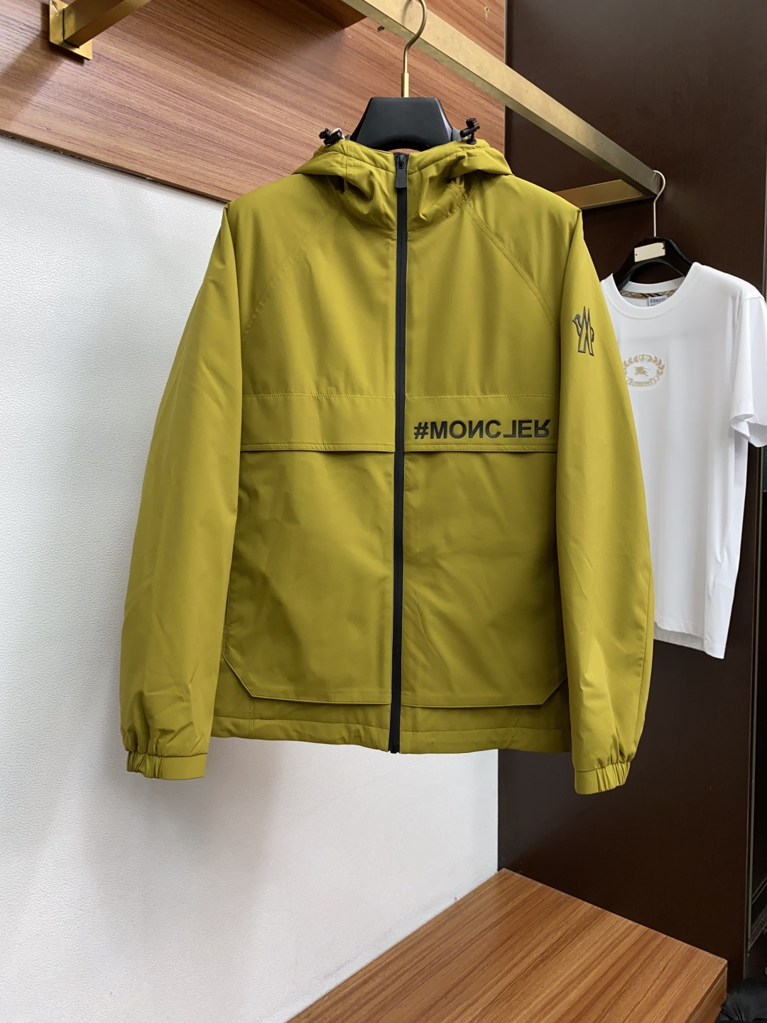 NO:526544,Mainly recommended (three-proof fabric, thin cotton, strong warmth) Moncler/Moss 25 new Foret Black Label Ski Series Men's Hooded Jacket Jacket Size M-3xL offers three color choices: white, black and yellow to meet the preferences and matching needs of different consumers. The hooded jacket jacket style is classic and practical, suitable for outdoor sports such as skiing, and is also suitable for daily wear. The brand logo sleeves have the iconic Moncler brand logo to enhance brand recognition; the front is decorated with '#MONCJER' to add a sense of fashion. The hooded design has obvious stitching technology in the hat part to increase three-dimensionality; the hat is equipped with black adjustment fasteners on both sides, so the elasticity of the hat can be adjusted according to needs. The main zipper is black, and the zipper head has exquisite brand-related patterns; the zipper head in the clothes is decorated with red, white and black color matching to add details.  The inner inner and outer jacket is gray, with a zippered pocket on the inner side, and the zipper is red, making it easy to store small objects. The product label standard ensures warmth. The outer material of the outer jacket is windproof and waterproof, suitable for outdoor sports environments such as skiing; the overall seams are fine and uniform, reflecting a high craftsmanship level. The middle triangle on the back is a gray leather patch with fine stitching and exquisite craftsmanship. There are regular perforations on the patch, which may be the brand's iconic pattern or symbol, which has both decorative and breathable functions, improving the design and practicality. The letter printing on the lower right of the back presents the words 'DAY-NAMIC', which are matched with pattern elements such as brand related peaks and animals. The font is clear, highlighting the brand's characteristics, strengthening the brand recognition, and adding the brand's exclusive style to the simple back, Moncler, jackets &  coats, jackets & coats,hats,alexander wang19860909主推（三防面料、加薄棉、保暖性强） Moncler/蒙口25新品Foret黑标滑雪系列男士连帽夹克外套 码数 M-3xL 提供白色、黑色和黄色三种颜色选择,满足不同消费者的喜好和搭配需求. 连帽夹克外套款式,经典且实用,适合滑雪等户外运动场景,也适合日常穿着. 品牌标志袖子上带有标志性的Moncler品牌标志,增强品牌辨识度；正面有“#MONCJER”字样装饰,增添时尚感. 连帽设计,帽子部分有明显的缝线工艺,增加立体感；帽子两侧配备黑色调节扣件,可以根据需求调整帽子的松紧. 主拉链为黑色,拉链头上有精致的品牌相关图案；衣服口袋拉链头带有红、白、黑配色装饰,增加细节亮点. 内里外套内里为灰色,在内里一侧设有带拉链的口袋,拉链为红色,方便存放小物件. 产品标签标准 ,保证了保暖性能. 外套外层材质具备防风、防水性能,适合滑雪等户外运动环境；整体缝线细密均匀,体现出较高的工艺水准. 背面中间三角形 是灰色皮质贴片,边缘缝线细密,工艺精致 .贴片上有规律穿孔,可能是品牌标志性图案或符号,兼具装饰性与透气功能,提升设计感与实用性. 背后右下方字母印花呈现 “DAY-NAMIC” 字样,搭配品牌相关山峰、动物等图案元素,字体清晰,彰显品牌特色,强化品牌识别度,为简约的背面增添品牌专属风格,,Moncler,jackets & coats,jackets & coats,hats,alexander wang,Men's clothing