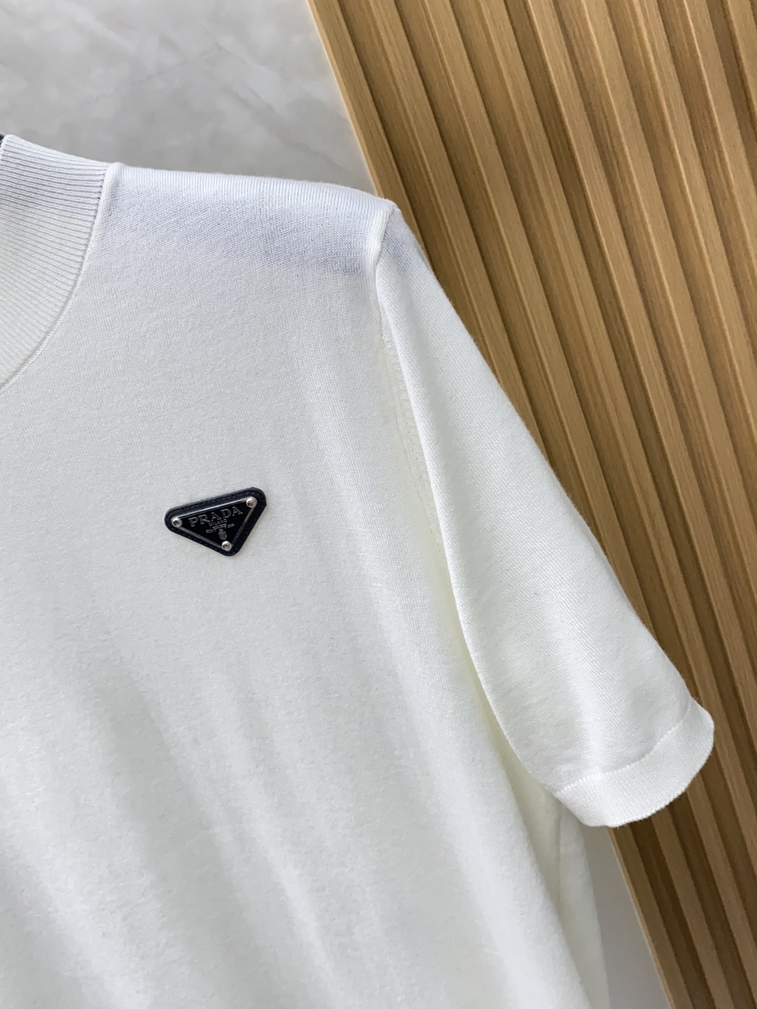 普拉达 圆领短袖羊毛衫，用细腻纤维编织时光韵味，于一针一线间，诉说永恒优雅，在男士高端针织服饰领域，这款