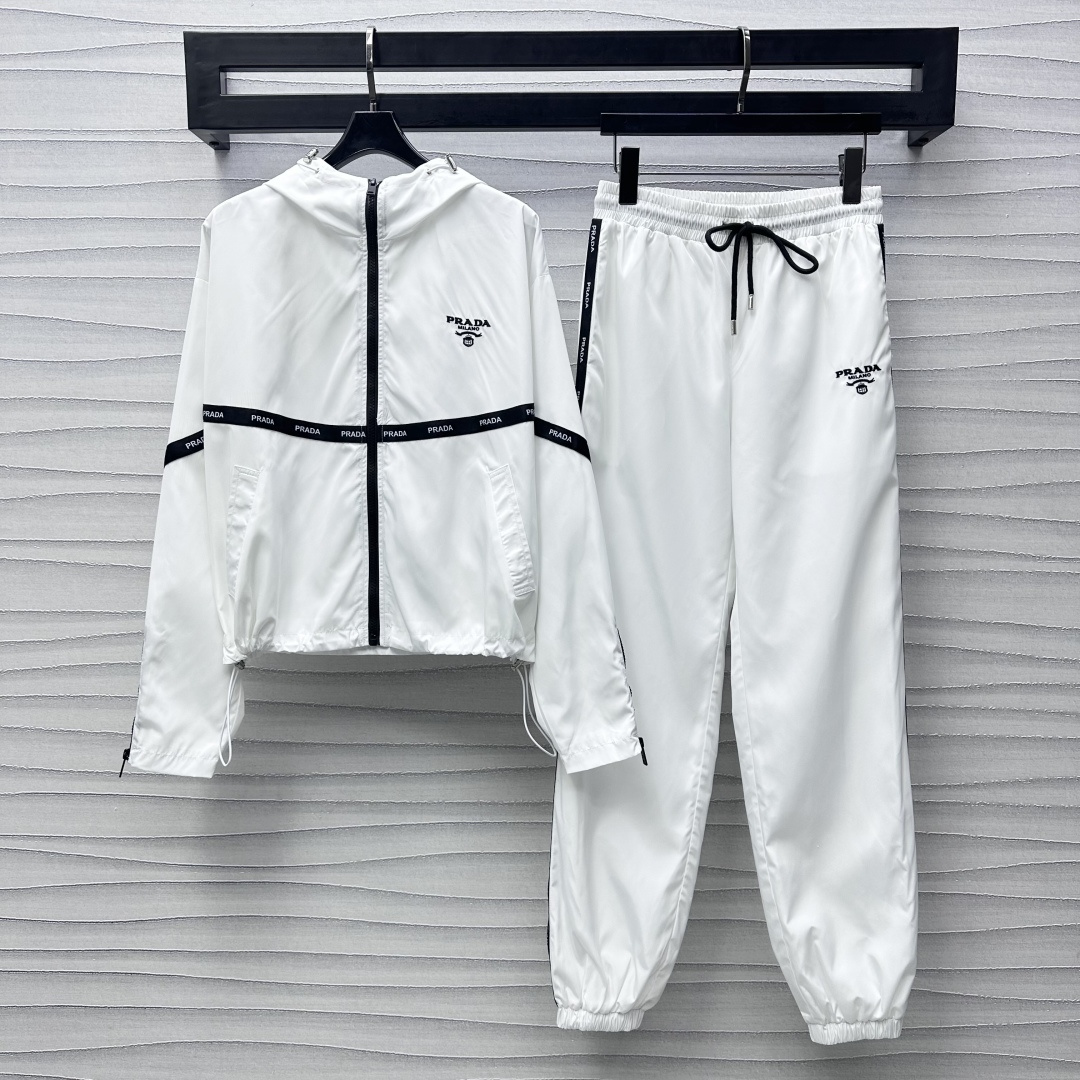 NO:317115,Prad*2025 new product hooded jacket trousers set customized YB imported windproof and waterproof nylon material comfortable and easy to wear, crisp and stylish, surface auxiliary material development Hooded jacket jacket trousers casual suit The front edge of the chest is adjusted with open zipper, combined with letter webbing splicing design to add layering, casual and fashionable The iconic embroidery brand embellishment decoration on the chest, matched with the same series of drawstring feet trousers, logo letter webbing echoes up and down, highlighting the brand tone, setting the trend positioning, the best choice for daily casualness of the upper body, fashionable and fashionable, high version 2 colors,,prada, jackets & coats, jackets & coats,hats,alexander wang19860909Prad*2025新品上架连帽夹克长裤套装定制YB进口防风防水尼龙材质 舒适好穿 挺括有型 面辅料开发 连帽夹克外套长裤休闲套装 胸前沿用开襟拉链调节处理 配合字母织带拼接设计 增添造型层次感 休闲时尚 胸前标志性刺绣品牌标点缀装饰 搭配同系列抽绳束脚长裤 徽标字母织带上下呼应 彰显品牌调性 奠定潮流定位 成套上身日常休闲的不二之选 穿搭时髦洋气  高版本2色,,prada,jackets & coats,jackets & coats,hats,alexander wang,Women's clothing
