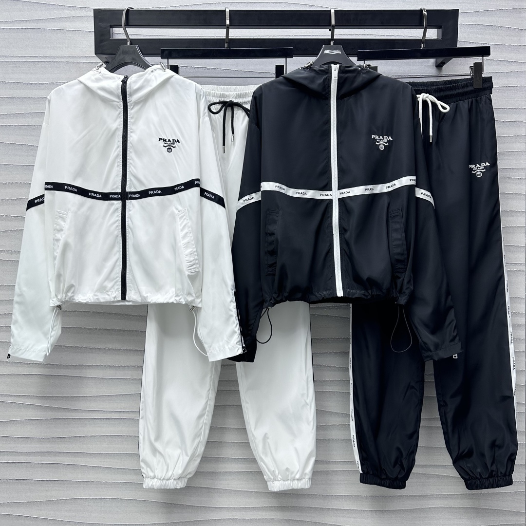 NO:317111,Prad*2025 new product hooded jacket trousers set customized YB imported windproof and waterproof nylon material comfortable and easy to wear, crisp and stylish, surface auxiliary material development Hooded jacket jacket trousers casual suit The front edge of the chest is adjusted with open zipper, combined with letter webbing splicing design to add layering, casual and fashionable The iconic embroidery brand embellishment decoration on the chest, matched with the same series of drawstring feet trousers, logo letter webbing echoes up and down, highlighting the brand tone, setting the trend positioning, the best choice for daily casualness of the upper body, fashionable and fashionable, high version 2 colors,,prada, jackets & coats, jackets & coats,hats,alexander wang19860909Prad*2025新品上架连帽夹克长裤套装定制YB进口防风防水尼龙材质 舒适好穿 挺括有型 面辅料开发 连帽夹克外套长裤休闲套装 胸前沿用开襟拉链调节处理 配合字母织带拼接设计 增添造型层次感 休闲时尚 胸前标志性刺绣品牌标点缀装饰 搭配同系列抽绳束脚长裤 徽标字母织带上下呼应 彰显品牌调性 奠定潮流定位 成套上身日常休闲的不二之选 穿搭时髦洋气  高版本2色,,prada,jackets & coats,jackets & coats,hats,alexander wang,Women's clothing