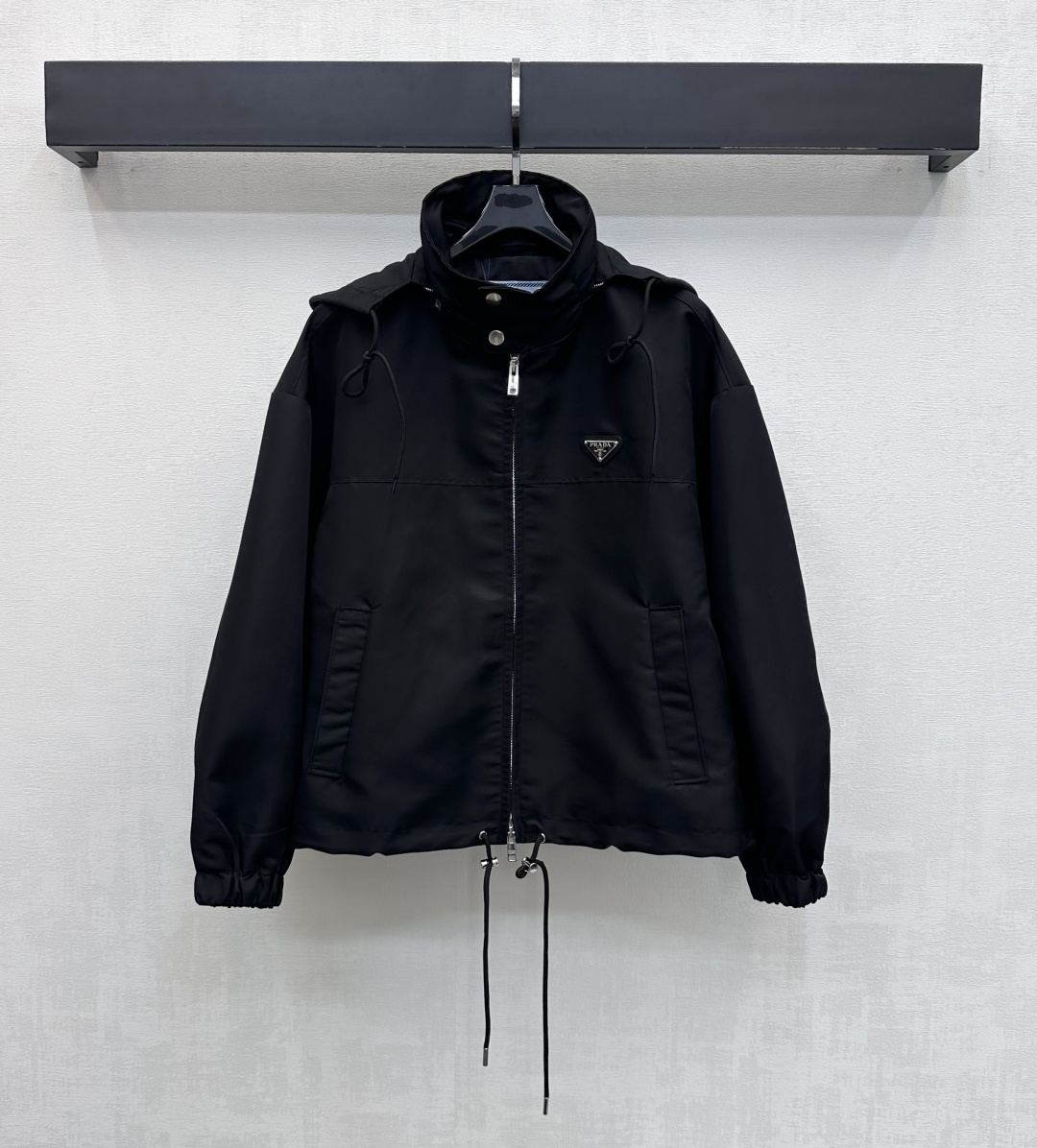 NO:665035,Prad*2026 new products are on the shelves. Hooded drawstring jacket. Customized YB imported windproof and waterproof nylon material. Stiff and stylish. High-quality texture. The iconic metal triangular letter logo element is embellished on the chest to highlight the brand tone. The engraved two-way zipper is used to adjust the placket and the drawstring tightening design at the hem. It is made with a hidden hood to add layering to the look. Surface accessories development. Jacket jacket to create an elegant silhouette. Daily jackets and windbreakers are layered, trendy and fashionable.  high version,,prada,jackets & coats,jackets & coats,hats, 19860909Prad*2026新品上架 连帽抽绳冲锋衣外套 定制YB进口防风防水尼龙材质 挺括有型 质感上乘 胸前点缀标志性金属三角形字母徽标元素 彰显品牌调性 沿用刻印双向拉链调节开襟配合下摆抽绳收紧设计 搭配隐藏式连帽制作 增添造型层次感 面辅料开发 冲锋风衣夹克外套 打造优雅的轮廓 日常夹克风衣叠穿 潮流时髦  高版本,,prada,jackets & coats,jackets & coats,hats, ,Women's clothing
