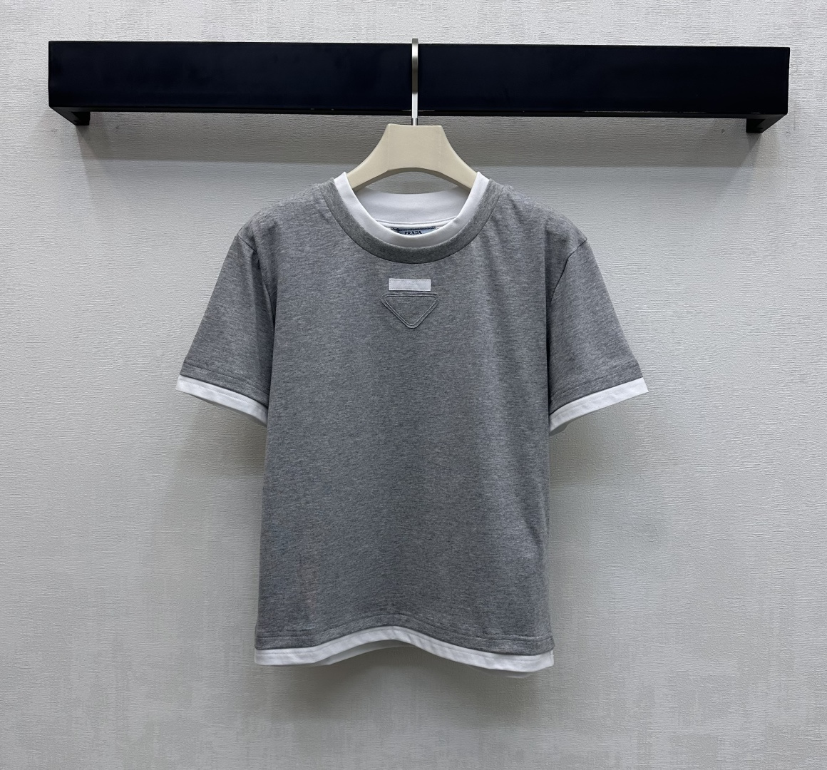 NO:667129,Prad*2025 new product launch round neck cloth logo short sleeves customized YB imported virgin twill cotton material, breathable, comfortable and full of texture. The collar hem and cuffs are processed with white contrasting thread binding details to add a sense of layering. The triangle cloth logo element design with iconic letters is embellished in the center of the chest to present an eye-catching and rich visual experience to highlight the brand tone. Development of surface accessories. Conventional round neck short sleeve T-shirt tailoring. Fashionable and casual for daily commuting. Outstanding and fashionable when worn alone.  High version 2 colors, prada, T-shirt, tees, t-shirt,  19860909Prad*2025新品上架圆领布标徽标短袖定制YB进口原生斜纹棉全棉材质 透气舒适 质感十足 领边下摆与袖口沿用白色撞色螺纹包边细节处理 增添造型层次感 胸前居中点缀标志性字母三角形布标徽标元素设计 呈现吸睛丰富视觉体验 彰显品牌调性 面辅料开发 常规圆领短袖T恤剪裁 日常通勤时尚休闲 单穿内搭出彩时髦  高版本2色,,prada,T-shirt,tees，t-shirt, ,Women's clothing