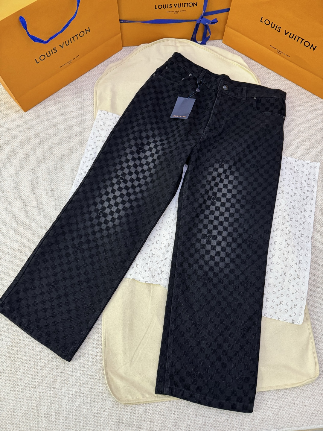 NO:702081,Exclusive original development of LOUIS VUITTON gradient checkerboard flocked denim trousers  Process description: Made of pure cotton washed vintage denim, the fabric has been specially treated to give a natural distressed effect. The entire trousers are covered with Damier plaid flocking patterns of different shades, subtly integrating the brand's iconic checkerboard elements into the design. The waistband is decorated with pearlescent buttons and metal rivets for decorative details, highlighting exquisite craftsmanship. The classic five-pocket jeans cutting design retains the practical function of traditional denim pants while giving it a modern and fashionable silhouette. The trousers are integrated with Marque L.Vuitton in many places.  The Déposée flocking logo shows the brand's genes in a low-key manner. The Damier nubuck leather material label is decorated on the back waist, which has a delicate touch. This style can be matched with the jacket of the same series to create a complete casual look. The overall design perfectly combines traditional denim craftsmanship with Louis Vuitton's iconic elements, which is comfortable and practical without losing the luxurious texture. Color black Size 30/32/34/36, Louis Vuitton-clothing, louis vuitton, louis  vuitton,jeans,jackets & coats,19860909独家原版开发LOUIS VUITTON渐变棋盘格植绒牛仔长裤 工艺说明采用纯棉水洗复古丹宁布制成,面料经过特殊处理呈现自然做旧效果.整条裤身铺陈深浅不一的Damier格纹植绒图案,将品牌标志性的棋盘格元素巧妙融入设计.裤腰处点缀珠光纽扣,搭配金属铆钉装饰细节,彰显精致工艺.经典的五袋式牛仔裤剪裁设计,既保留传统丹宁裤的实用功能,又赋予现代时尚廓形.裤身多处融入Marque L.Vuitton Déposée植绒标识,低调展现品牌基因.后腰处饰有Damier正绒面革材质标签,触感细腻.该款可与同系列夹克搭配,打造完整休闲造型.整体设计将传统丹宁工艺与路易威登标志性元素完美结合,既舒适实穿又不失奢华质感. 颜色黑色 尺码30/32/34/36,路易威登-服装,louis vuitton,louis vuitton,jeans,jackets & coats,,Women's clothing