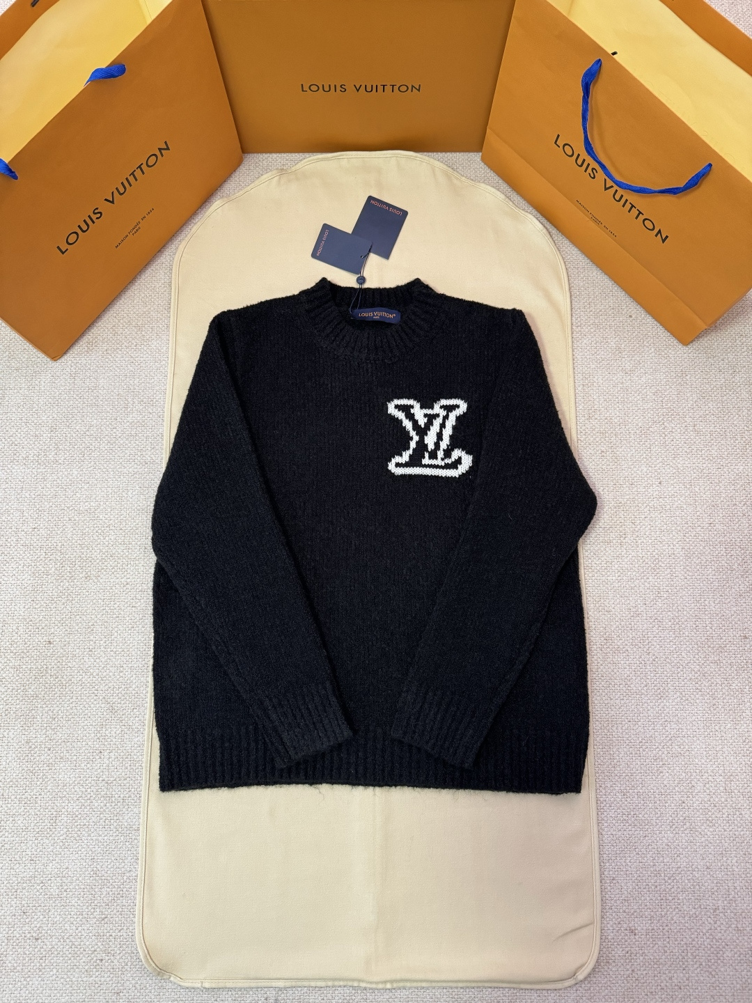 P210 独家原版开发LOUIS VUITTON字母嵌花针织毛衣 工艺说明：采用100%纯绵羊毛面料制作，柔软亲肤质感，穿着舒适无刺痒感。面料兼具保暖性与透气性，带来全天候舒适体验。胸前饰以经典LV字母嵌花图案，后身呈现镜像效果标识，均采…