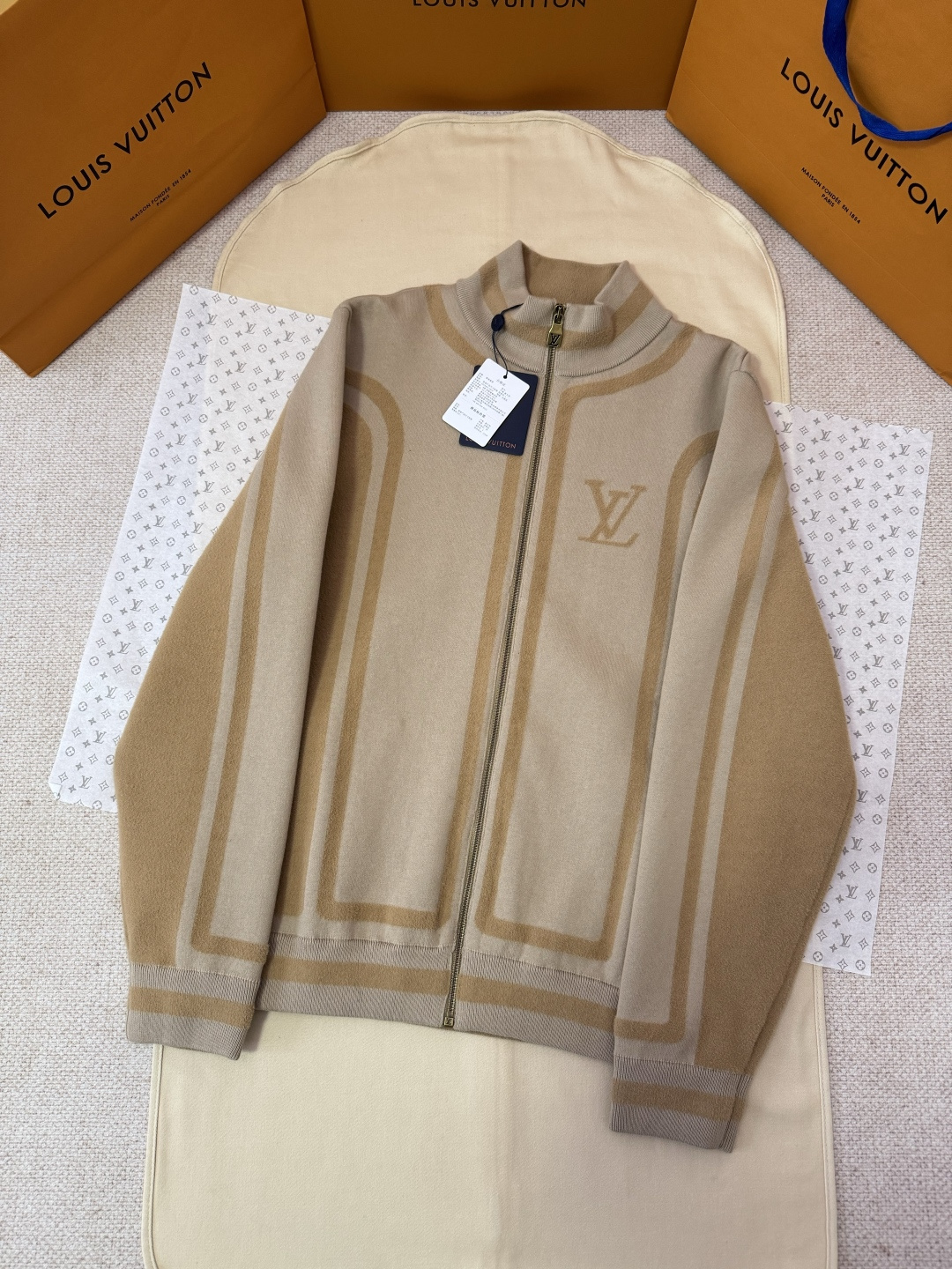 NO:637518,Exclusive original development of LOUIS VUITTON two-color splicing intarsia zipper jacket [same style as Wang Hedi]  Process description: Made of 43 nylon, 32 cotton and 25 viscose blended fabric, it has both comfort and stiffness. The designer uses two-tone intarsia technology to let contrasting color strips run through the sleeves and body, forming a smooth visual extension. Different areas create a subtle three-dimensional texture effect by changing the knitting density and stitching. The chest is decorated with a delicate intarsia LV logo, and the back is presented in elegant fonts  The word Vuitton is now displayed, and the details are full of brand recognition. The collar, cuffs and hem made of rib knitting technology not only enhance the stability of the silhouette, but also echo the overall design language. The front uses a smooth zipper opening and closing, and there are practical pockets on both sides, taking into account functionality. The whole piece perfectly interprets the exquisite aesthetics of sports and leisure style through the ingenious combination of fabric texture and craftsmanship details.  Color Khaki Size S/M/L/XL,Louis Vuitton-Clothing,louis vuitton,louis vuitton,louis vuitton,jackets & coats,alexander wang19860909独家原版开发LOUIS VUITTON双色拼接嵌花拉链外套【王鹤棣同款】 工艺说明采用43锦纶、32棉与25粘胶纤维混纺面料制成,兼具舒适度与挺括感.设计师运用双色调嵌花工艺,让对比色条带贯穿衣袖与衣身,形成流畅的视觉延伸.不同区域通过变换针织密度与针法,塑造出微妙的立体纹理效果.胸前饰以精致的嵌花LV标识,背部则以优雅字体呈现Vuitton字样,细节处尽显品牌辨识度.罗纹针织工艺打造的衣领、袖口及下摆,不仅增强了廓形稳定性,更与整体设计语言相呼应.前襟采用顺滑拉链开合,两侧设有实用插袋,兼顾功能性.整件作品通过面料质感与工艺细节的巧妙结合,完美诠释了运动休闲风格中的精致美学. 颜色卡其色 尺码S/M/L/XL,路易威登-服装,louis vuitton,louis vuitton,louis vuitton,jackets & coats,alexander wang,Women's clothing