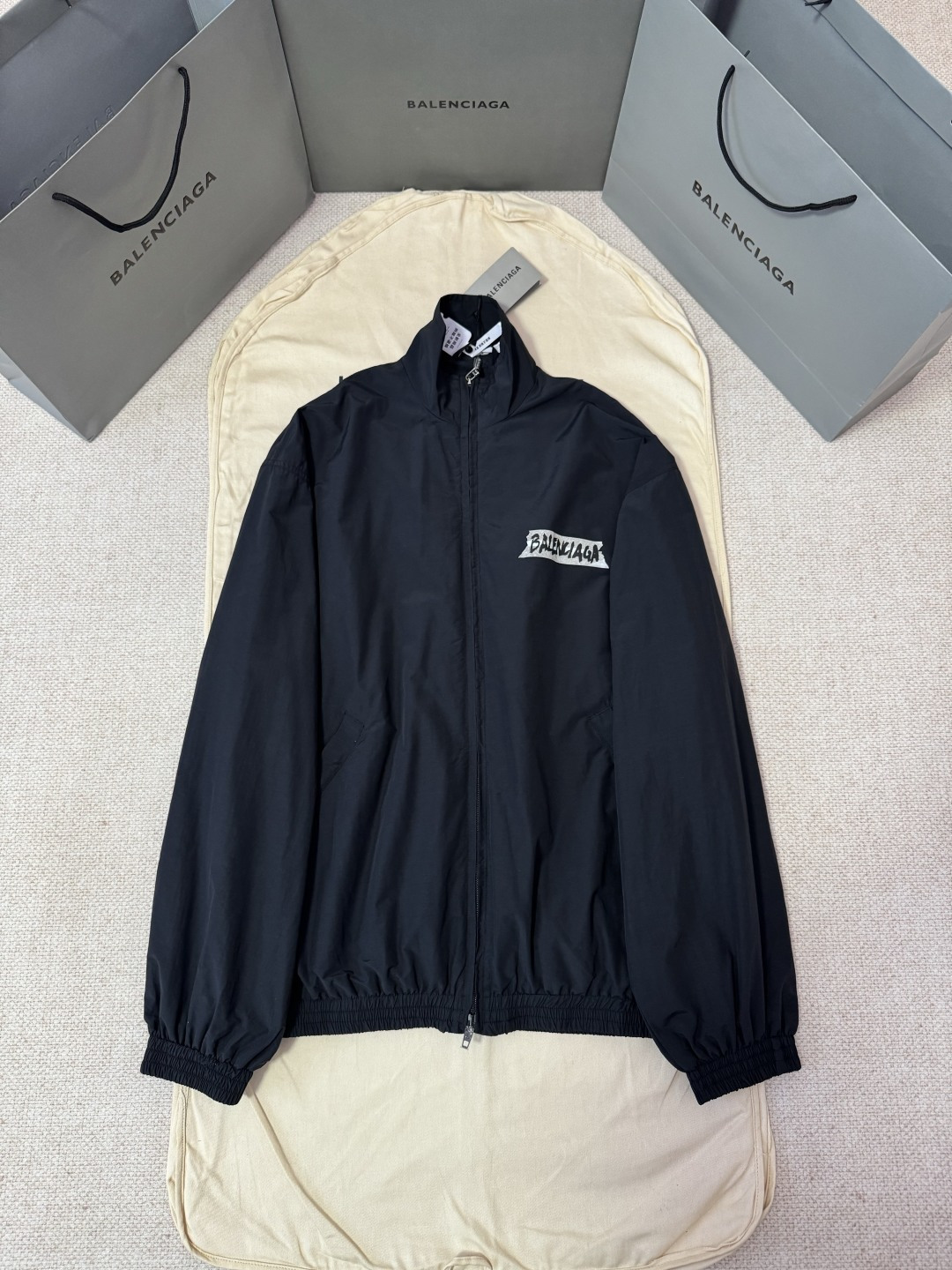 P265 Balenciaga胶浆印花夹克外套 工艺说明：Balenciaga Masking Tape Tracksuit夹克以革新面料与标志性艺术细节构筑其先锋轮廓。主体采用黑色科技棉混纺府绸，这种面料在传统棉质舒适基础上，融入了高科…