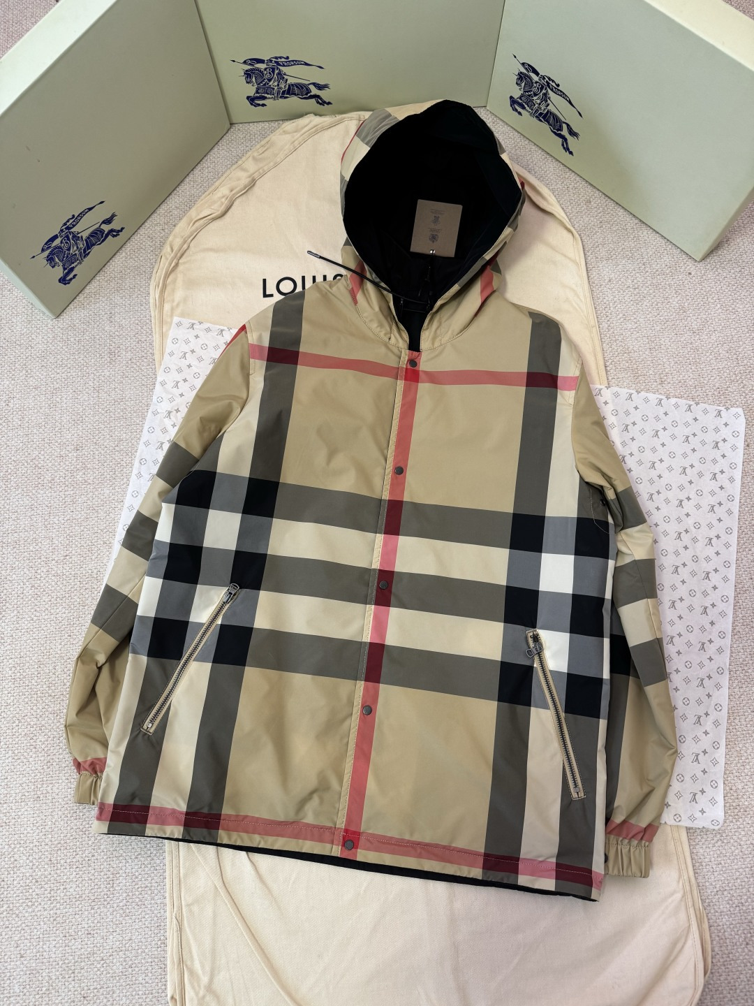 NO:743793,The original development of BURBERRY's classic large plaid reversible jacket. The process description adopts the same design for men and women. This jacket is reversible, one side is made of solid color taffeta fabric, and the front chest is decorated with a three-dimensional silicone Burberry logo; the other side is the brand's iconic Vintage plaid, which is made of custom-woven and dyed high-density nylon fabric. The plaid is precisely aligned and laser cutting technology is used to ensure pattern continuity.  The craftsmanship details show the ingenuity. Both sides use snap placket, with drawstring hood and hem adjustment, taking into account both practicality and beauty. One side is equipped with snap welt side pockets, which is simple and neat; the other side is equipped with zipper pockets and elastic snap button cuffs, which is a regular fit.  It is crisp. The entire jacket is carefully selected with custom-made hardware accessories, neatly sewn, precise in pattern, and of outstanding quality. The OEM has strict quality control to ensure that it can be worn on both sides to show exquisite craftsmanship and elegance. It is an ideal choice for both function and style in early autumn.  Color Khaki SizeS/M/L/XL,Burberry-clothing,burberry,jackets & coats,jackets & coats,hats,19860909原版开发BURBERRY经典大格纹双面穿夹克外套 工艺说明采用男女同款设计.本款夹克为双面两穿款式,一面为纯色塔夫绸面料,前胸饰有立体硅胶Burberry徽标；另一面为品牌标志性Vintage格纹,采用定织定染的高密度锦棉面料,格纹精准对位,通过激光裁片技术确保图案连贯. 工艺细节彰显匠心双面均采用按扣开襟,配以抽绳式连帽与衣摆调节,兼顾实用与美观.一面设有按扣式贴边侧袋,简洁利落；一面搭配拉链口袋与弹性按扣袖口,版型常规挺括.整件外套精选定制五金配件,缝制工整,对格精确,品质出众.代工厂严格品控,确保双面穿着皆呈现精湛工艺与优雅风貌,是早秋季节兼具功能与风格的理想之选. 颜色卡其色 SizeS/M/L/XL,博柏利-服装,burberry,jackets & coats,jackets & coats,hats,,Women's clothing