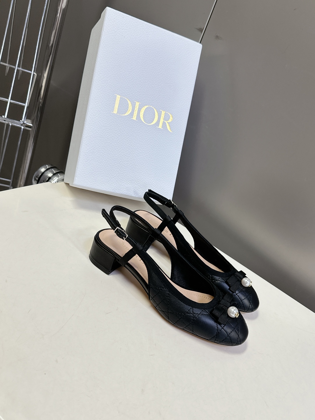  Dior迪奥春夏新款菱格后空时装鞋
   时尚优雅，饰以白色树脂珠饰和 CD 标志 圆头设计与粗跟相得