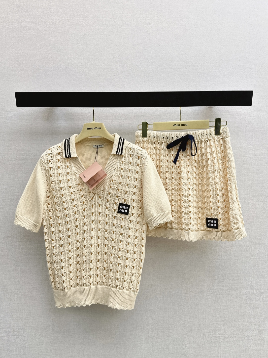 NO:762495,Miu 26Ss————The latest age-reducing Miu style outfit for spring and summer. Hollow lapel short sleeves + Mini skirt. The micro-hollow design is super breathable and super comfortable to wear in summer. The short sleeves are lapels + stripes. Full of college style. There is a brand logo detail on the left chest. Short skirt drawstring design, adjustable elasticity. Suitable for daily leisure or vacation. The overall style is playful and age-reducing. Easily get a variety of summer looks. One set.  Two colors ready for sale sml,,miumiu,skirts,T-shirt,19860909Miu 26Ss————春夏最新款减龄缪系穿搭套装镂空翻领短袖+Mini半裙 微镂空设计超透气 夏天穿超舒服 短袖是翻领+条纹 学院风满满 左胸有品牌标志细节感拉满 短裙抽绳设计,松紧可调 日常休闲或度假都很适合 整体风格俏皮减龄 轻松get夏日多变造型 一套出 两色现货发售sml,,miumiu,skirts,T-shirt,,Women's clothing