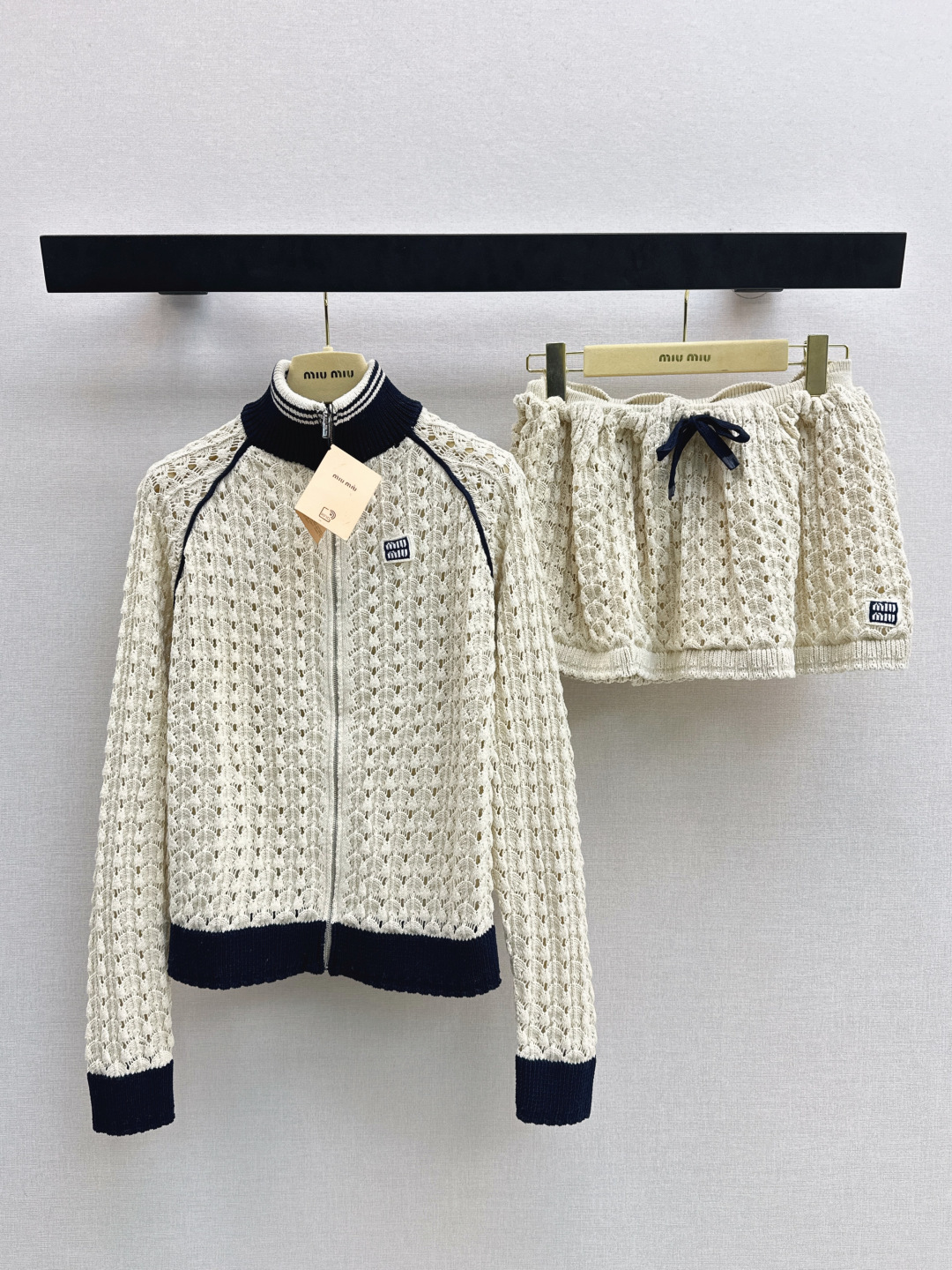 NO:791056,Jacket Skirt Miu 26Ss - the latest spring and summer age-reducing Miu style outfit. Beige hollow knitted cardigan + mini skirt. Made of soft waxy yarn. Hand-crocheted scallop texture. Transparent and layered. Black ribbed stand-up collar. Contrast color design on cuffs and hem. Full score for sweet and cool style. Full zipper for easy putting on and taking off. It looks great with a skirt.  Easily create a retro college style or an age-reducing fashion look. Square micro-labels are low-key and elegant. Essential items for early spring wear are available in one color. Available in stock sml,,miumiu,skirts,jackets & coats,19860909外套 半裙Miu 26Ss————春夏最新款减龄缪系穿搭套装米杏色镂空针织开衫+mini半裙 采用软糯纱线 手工钩织扇贝纹理 通透又有层次感 黑色罗纹立领 袖口和下摆撞色设计 甜酷风格满分 全拉链方便穿脱 搭配半裙一套上身非常出彩 轻松打造复古学院风或减龄时尚造型.方形微标低调显贵早春穿搭必备单品获 一色分开发 现货发售sml,,miumiu,skirts,jackets & coats,,Women's clothing