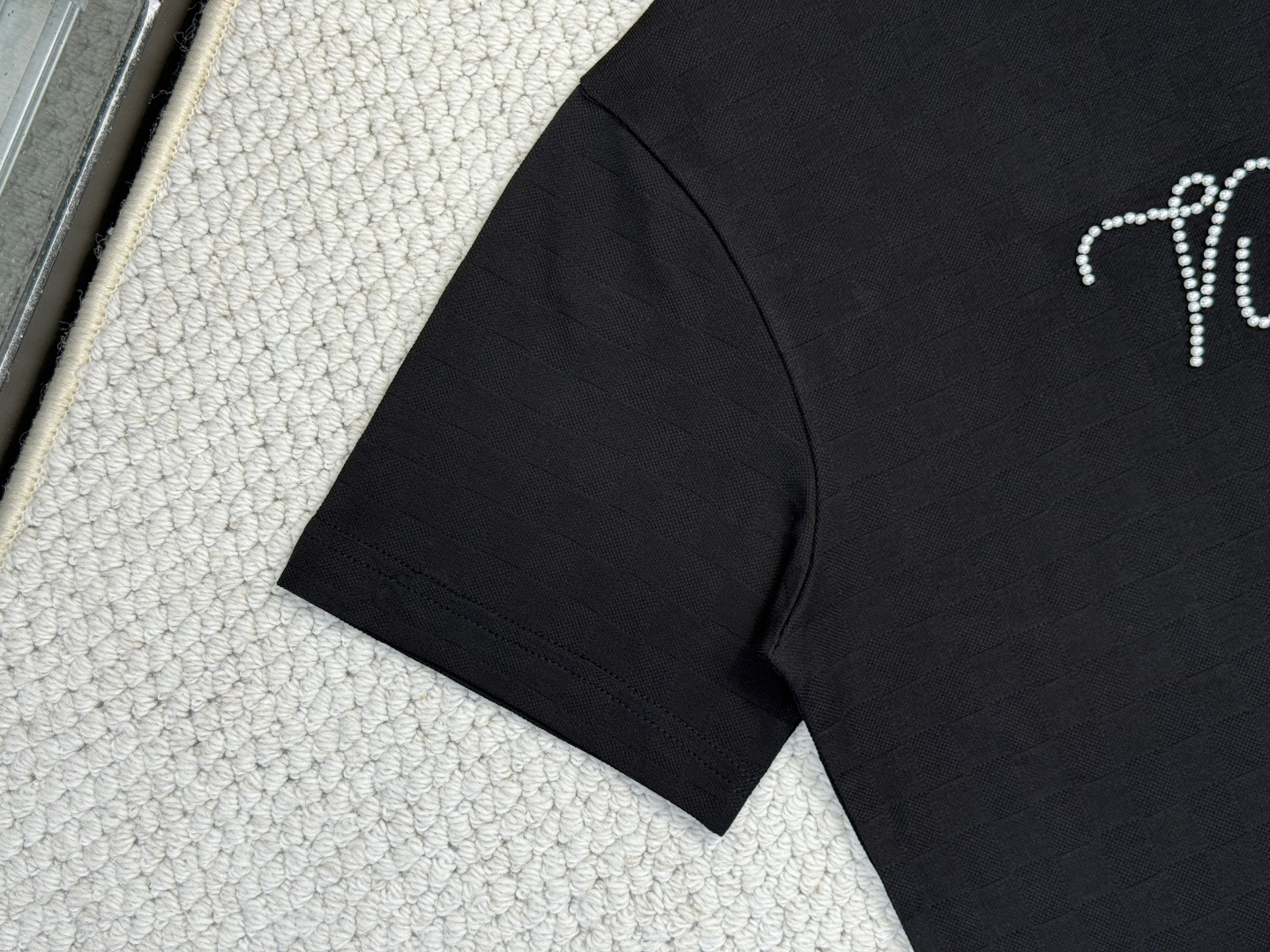 LV-产品简介1V / 珠地装饰细节T恤本款珠地棉T恤以 Damier 提花呈现细腻肌理，再以莹亮串珠于