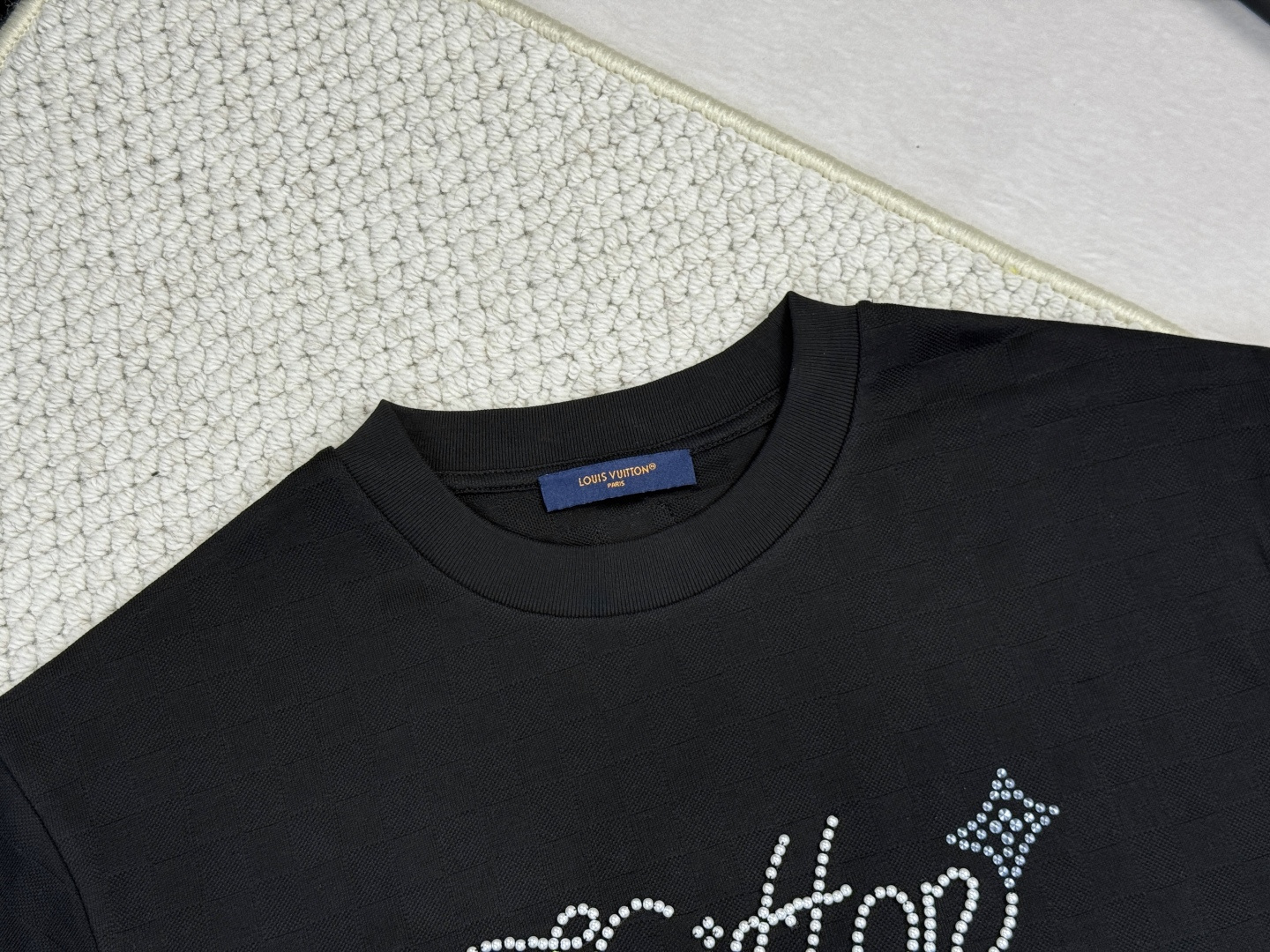 LV-产品简介1V / 珠地装饰细节T恤本款珠地棉T恤以 Damier 提花呈现细腻肌理，再以莹亮串珠于