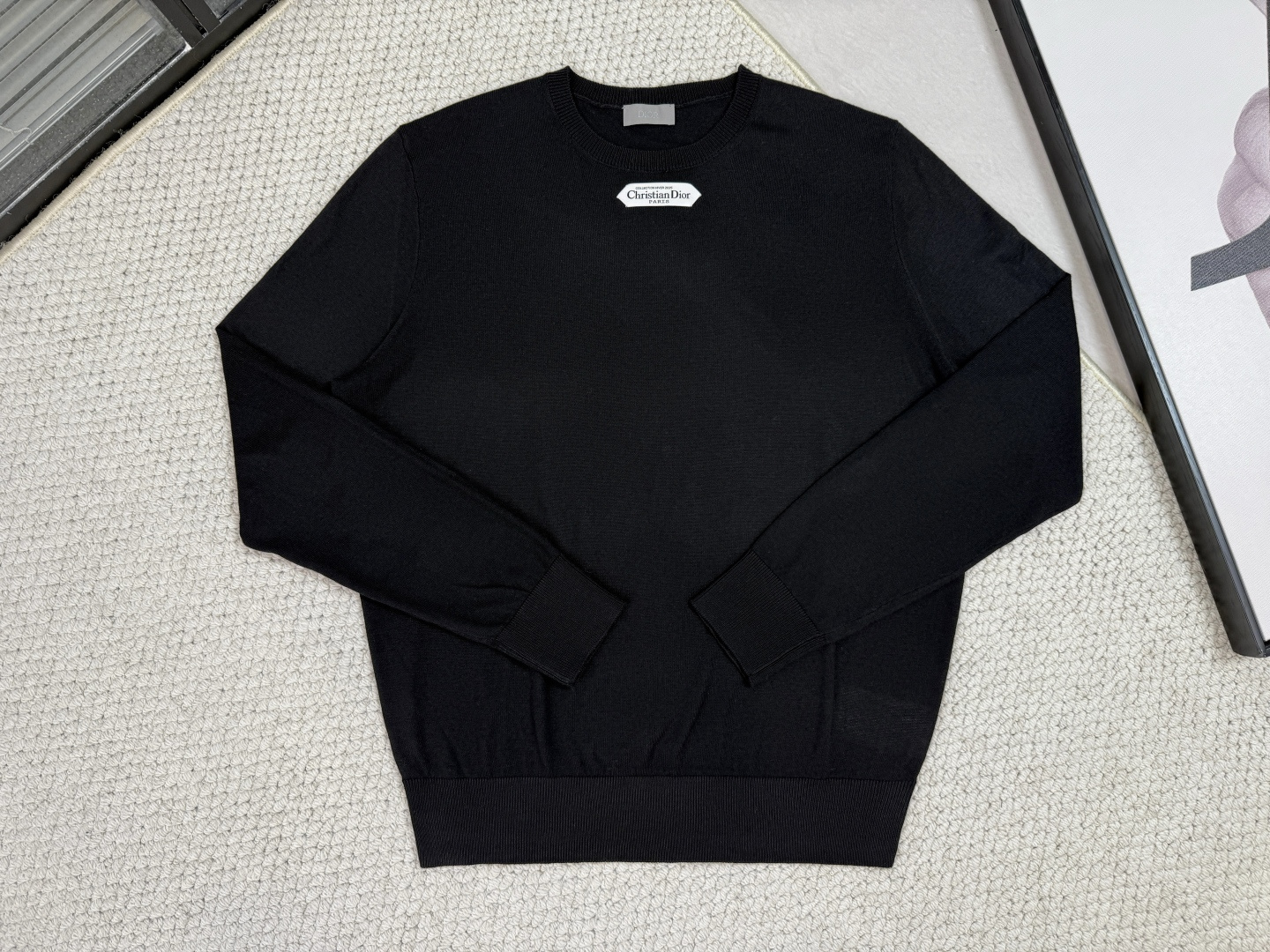 NO:531585,Dior - Product Introduction CD / Wrinkled round neck shirt Black, beige, light pink This sweater is decorated with logo labels, paying tribute to the high-order spirit and the extraordinary exquisite craftsmanship of the workshop. It is carefully crafted with blended wool jersey fabrics, with a unique texture. It can be worn with jeans and tailored trousers to create an elegant and classic look. Jersey creates a delicate, soft and skin-friendly, crisp and elastic fabric, taking into account warmth and breathability, and the wool color highlights the texture. Based on simple tailoring, the ribbed round neck, cuffs and hem is exquisitely processed to enhance fit and durability, and keep the style long and neat.  The brand label embellishment on the chest is woven using double-sided jacquard technology as the brand’s iconic details; the black thread is embedded in the white base, or miniature letters are formed through yarn density. The edges of the label are laser cut, without defects such as yarn leakage.,,dior,jeans,alexander wang19860909迪奥-产品简介 CD / 平纹毛织圆领衫 颜色黑色、米白、浅粉 这款针织衫饰以标志标签,致敬的高订精神和工坊非凡的精湛工艺.采用混纺绵羊毛平纹针织面料精心制作,精致柔软的质感别具特色.可搭配牛仔裤和精裁长裤穿着,打造高雅经典的造型. 以平纹针织打造出质感细腻、柔软亲肤且挺括有弹性的面料,兼顾保暖与透气性,毛料色泽凸显质感.简约剪裁为基础,通过罗纹圆领、袖口和下摆的精工处理,增强贴合度与耐久性,保持版型持久利落. 胸前的品牌标签点缀,作为品牌标志性细节采用双面提花技术织造而成；黑色线嵌入白色基地,或通过纱线密度形成微缩字母.标签边缘通过激光切割处理,无走纱漏纱等瑕疵.,,dior,jeans,alexander wang,Men's clothing