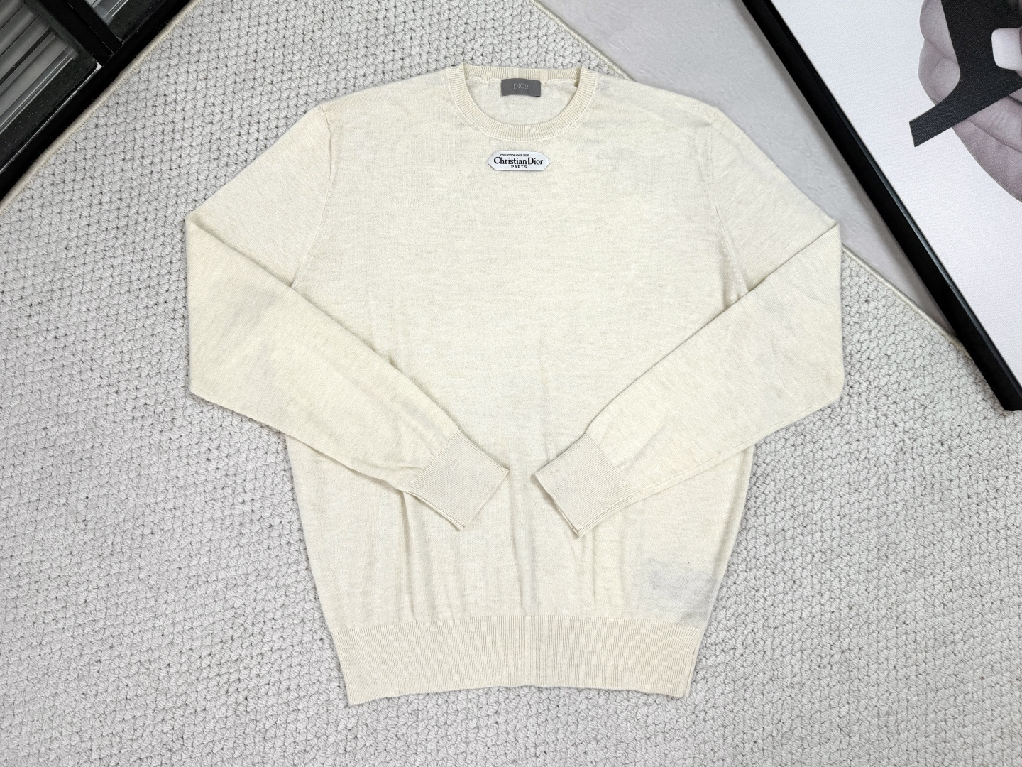 NO:531582,,Dior - Product Introduction CD / Wrinkled round neck shirt Black, beige, light pink This sweater is decorated with logo labels, paying tribute to the high-order spirit and the extraordinary exquisite craftsmanship of the workshop. It is carefully crafted with blended wool jersey fabrics, with a unique texture. It can be worn with jeans and tailored trousers to create an elegant and classic look. Jersey creates a delicate, soft and skin-friendly, crisp and elastic fabric, taking into account warmth and breathability, and the wool color highlights the texture. Based on simple tailoring, the ribbed round neck, cuffs and hem is exquisitely processed to enhance fit and durability, and keep the style long and neat.  The brand label embellishment on the chest is woven using double-sided jacquard technology as the brand’s iconic details; the black thread is embedded in the white base, or miniature letters are formed through yarn density. The edge of the label is laser cut, without defects such as yarn leakage.,,dior,dior,jeans,alexander wang19860909,Dior迪奥-产品简介 CD / 平纹毛织圆领衫 颜色黑色、米白、浅粉 这款针织衫饰以标志标签,致敬的高订精神和工坊非凡的精湛工艺.采用混纺绵羊毛平纹针织面料精心制作,精致柔软的质感别具特色.可搭配牛仔裤和精裁长裤穿着,打造高雅经典的造型. 以平纹针织打造出质感细腻、柔软亲肤且挺括有弹性的面料,兼顾保暖与透气性,毛料色泽凸显质感.简约剪裁为基础,通过罗纹圆领、袖口和下摆的精工处理,增强贴合度与耐久性,保持版型持久利落. 胸前的品牌标签点缀,作为品牌标志性细节采用双面提花技术织造而成；黑色线嵌入白色基地,或通过纱线密度形成微缩字母.标签边缘通过激光切割处理,无走纱漏纱等瑕疵.,,dior,dior,jeans,alexander wang,Men's clothing