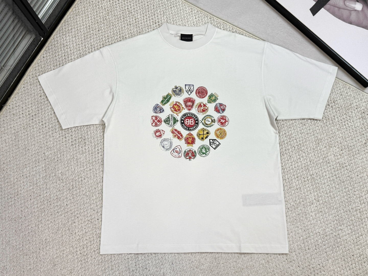 NO:531603,, Lv-Product Introduction XS-L Paris / Oversized Printed and Embroidered T-shirt Fabric 24S Double Yarn Special Textile Tight Cotton / 185g Ribbed 32S Double Yarn Pull Rack / 340g Pure cotton fabric structure is plain weave, the fabric surface of the fabric is flat and delicate, with a tight texture, with good moisture absorption, breathability and comfort, and can maintain dryness and comfort. Due to its tight spinning process, it also has good wrinkle resistance and durability, which is suitable for long-term wear or use. The multi-layer stacking process of dark slurry dots adopts precision screen technology to cover the translucent printing paste on the fabric through multiple layers. Each layer is stacked and fused with micron tolerances, and through subtle changes in the thickness and density of the paste, an invisible pattern with a transition of depth and shallowness on the surface of the fabric is formed.  This technology uses physical accumulation to replace color contrast, and uses the diffuse reflection of light on the concave and convex surface to present a looming light and shadow relief effect, creating a high-end printing with visual haze and tactile three-dimensionality, perfectly fitting the low-key and luxurious design aesthetics.,,louis vuitton,tees,t-shirt,alexander wang19860909、 Lv-产品简介XS- L 巴黎 / 大廓形印绣T恤 面料24S双纱特种纺织紧密棉 / 185g 罗纹32S双纱拉架 / 340g 纯棉质织物组织结构为平纹,面料的织物表面平整细腻,质地紧密,具有良好的吸湿透气性和舒适性,能够保持干爽舒适.由于其紧密的纺纱工艺,它也具有良好的抗皱性和耐久性,适合于长时间穿着或使用. 暗花浆网点多层叠加工艺采用精密网版技术,将半透明印花浆料通过多次分层印制覆盖于织物.每一层以微米级公差叠压融合,通过浆料厚度与密度的微妙变化,在面料表面形成具有深浅过渡的隐形纹样. 该技术以物理堆积替代色彩对比,利用光线在凹凸表面的漫反射呈现若隐若现的光影浮雕效果,造就兼具视觉朦胧感与触觉立体性的高级印花,完美契合低调奢华的设计美学.,,louis vuitton,tees，t-shirt,alexander wang,Men's clothing