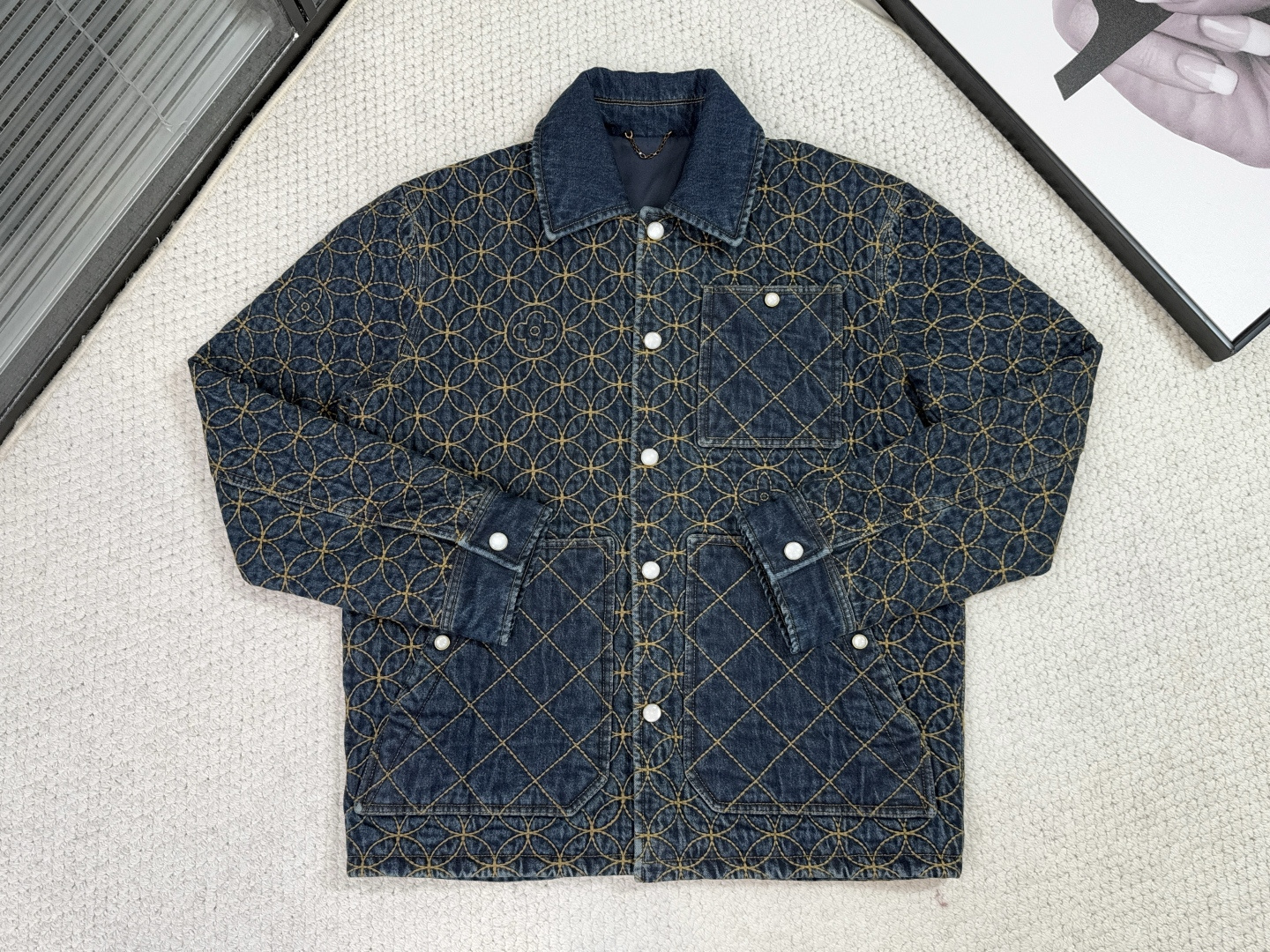 NO:531609,Lv-Louis Vuitton-Product Introduction 1V / Embroidered denim waist jacket This denim workwear waist jacket is a collaboration series jointly created by the 2025 autumn and winter show, showing the brand's exquisite craftsmanship. The full quilted DandyMonogram pattern embellishes the logo, revealing the Japanese aesthetic heritage. The pearlescent buttons reveal an elegant atmosphere, which is suitable for matching with the same shorts. Washed denim fabric gives the jacket a retro workwear background, and the embroidered logo and smooth lining form a rough and exquisite contrast. The embroidery uses chain needle method to strengthen durability, and all stitches are reinforced to reflect the detailed control of high-end products.  The pattern is penetrated through the clothes body with full-frame precision quilting technology, and the polyester fiber filling and outer denim fabric are fixed through concave and convex stitches, which not only ensures warmth uniformity, but also transforms the classic logo into a three-dimensional texture, realizing the artistic combination of filling function and brand symbols. Using denim as a carrier, through the quilting process, material comparison and cultural symbol reconstruction, an iconic cotton jacket that balances the sense of street and luxury.,,louis vuitton,louis vuitton,shorts,jackets & coats,jackets & coats,alexander wang19860909Lv-路易威登-产品简介 1V / 刺绣牛仔束腰夹克 本款牛仔工装束腰夹克出自2025秋冬秀场联袂打造的合作系列,尽显品牌精湛匠艺.全幅绗DandyMonogram图案点缀标识,道出日式美学传承.珠光纽扣流露雅致气息,与同款短裤搭配相宜. 水洗牛仔面料赋予外套复古工装底蕴,刺绣标识与光滑内衬形成粗犷与精致的对比.刺绣采用链式针法强化耐久度,所有缝线均作加固处理,体现高端单品的细节控制力. 以全幅精密绗缝技术将图案贯穿衣身,通过凹凸线迹将聚酯纤维填充物与外层牛仔面料固定,既确保保暖均匀性,又使经典标识转化为立体肌理,实现填充功能与品牌符号的艺术化结合. 以牛仔为载体,通过绗缝工艺、材质对比与文化符号的重构,打造出一件平衡街头感与奢侈感的标志性棉服.,,louis vuitton,louis vuitton,shorts,jackets & coats,jackets & coats,alexander wang,Men's clothing