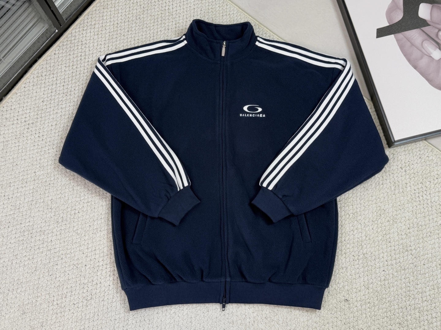 NO:540134,Product Introduction Paris Shijia - LOOP SPORTSICON Zipper Jacket The jacket is based on high-performance knitted fabric and is woven with blended material to ensure four-way elasticity and breathable quick-drying characteristics. The double-head zippers achieve flexible opening and closing, and are matched with condensed rib cuffs and waist to accurately fit the limbs to prevent heat loss; the two zipper oblique pockets are integrated into the body with three-dimensional cut, taking into account storage functions and smooth silhouettes. All stitching is reinforced to improve durability in sports scenes. The contrasting piping of the sleeves is outlined through precision edging technology to enhance the sense of line while avoiding curling deformation; the core front and back embroidery is combined with digital positioning technology to combine multi-color embroidery threads to bring Loop Sports  Icon art works are restored with high-density pins, with clear and three-dimensional edges, and dynamically adapted to elastic fabrics to avoid stretching and deformation, reflecting the combination of technology and handicrafts. The same style of men and women is combined with straight cut and local condensation, and a straight tumbled body and high-neck design balances the movement protection and street style, and the zipper oblique pockets integrate into the overall lines. Balance the looseness and neatness; the turtle collar design extends the protective area, and the contrasting color and white collar collision vibrant and calm. The whole is fusion of functional details and artistic embroidery.,, jackets & coats, jackets & coats, alexander wang19860909产品简介 巴黎 世家-LOOP SPORTSICON拉链夹克 外套以高性能针织面料为基底, 采用混纺材质编织,确保四向弹力与透气速干特性.双头拉链实现灵活开合,搭配缩褶罗纹袖口与腰围精准贴合肢体,防止热量流失；两个拉链斜口袋以立体剪裁融入衣身,兼顾储物功能与流畅廓形.所有缝线采用加固处理,提升运动场景下的耐久性. 衣袖撞色滚边通过精密包边工艺勾勒轮廓,强化线条感的同时避免卷边变形；核心的正背面刺绣以数字化定位技术结合多色绣线,将Loop Sports Icon艺术作品以高密度针脚还原,图案边缘清晰立体,且与弹性面料动态适配,避免拉伸变形,体现科技与手工艺的结合. 男女同款版型以直筒剪裁结合局部缩褶,以直筒衣身与高领设计平衡运动防护与街头风格,拉链斜口袋融入整体线条.平衡宽松度与利落感；高领设计延伸防护区域,净色与白色撞色碰撞活力与沉稳感.整体通过功能细节与艺术刺绣的融合.,,jackets & coats,jackets & coats,alexander wang,Men's clothing