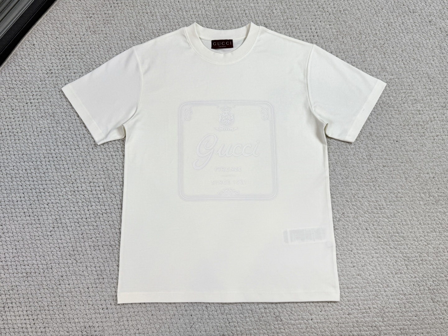 NO:712298,Gucci/Product Introduction GC / Soft knitted cotton T-shirt with archival print. Fabric 60-count single yarn double-sided / 170G ribbed 32-count double yarn / 300G. The 2026 early spring women's ready-to-wear collection pays homage to Gc fashion styling. It combines the brand's archive elements and Florentine heritage with interesting mixed colors, presenting simple styles and extremely complex designs. This T-shirt is made of knitted cotton and cleverly incorporates 'Gc  Firenze since1921' print.  Made of 60-count single yarn double-sided knitted cotton, the weight achieves a top-notch touch that is as light as a feather and as smooth as silk. The ultra-high-count yarn makes the fabric density reach more than 180 needles per square inch, and the cloth surface presents a delicate texture like baby skin, while having excellent breathability and drape. The neckline is matched with a 32-count double yarn high-density rib, and its weight provides the necessary collar support frame for the slim body to ensure that it does not deform when worn.  Slogan printing uses environmentally friendly elastic thick plate bright glue technology. The 1.2mm thick slurry is stacked through a special screen and cured at 140°C to form a mirror gloss relief effect. This process makes the pattern stretch-resilient, hard and smooth to the touch like a ceramic glaze, and forms a tactile polar collision with the soft fabric base. The printing layer is permanently combined with the fiber through molecular cross-linking technology, and its washability and wear resistance are far superior to ordinary offset printing.  It adopts a straight and slightly loose cut, and uses arc splicing under the armpits to leave room for movement. The neckline adopts double hemming technology to achieve the dual guarantee of smooth putting on and taking off and long-lasting shape. The hem and cuffs are reinforced with multi-needle four-thread seams, and all stitches are treated to prevent unraveling.,,gucci,tees,t-shirt,real silk,19860909Gucci古奇/产品简介 GC / 饰典藏印花柔软针织棉T恤 面料60支单纱双面 / 170G 罗纹32支双纱 / 300G 2026早春女士成衣系列致意Gc时尚造型,以混色搭配趣致糅合品牌典藏元素与佛罗伦萨传承意蕴,呈现简洁风格与极繁设计等多元单品.这款T恤甄选针织棉打造,巧妙融入'Gc Firenze since1921'印花. 采用60支单纱双面针织棉,克重实现了羽毛般轻盈与真丝般滑糯的顶级触感.超高支纱线使织物密度达到每平方英寸180针以上,布面呈现婴儿肌肤般的细腻肌理,同时具备优异的透气性与悬垂感.领口搭配32支双纱高密罗纹,其克重为纤薄衣身提供了必要的领型支撑骨架,确保穿着不变形. 标语印花运用环保弹力厚板光亮胶浆技术,通过特制网版进行1.2mm厚度浆料堆叠,经140℃高温固化形成镜面光泽浮雕效果.该工艺使图案具备拉伸回弹性,触感坚硬光滑如陶瓷釉面,与柔软面料基底构成触觉两极碰撞.印花层通过分子交联技术与纤维永久结合,耐洗耐磨性远超普通胶印. 采用直筒微宽松剪裁,在腋下采用弧形拼接预留活动余量.领口采用双重包边工艺,实现穿脱顺滑与形态持久双重保障.下摆及袖口以多针四线锁边进行加固,所有缝线经过防脱散处理.,,gucci,tees，t-shirt,real silk,,Men's clothing