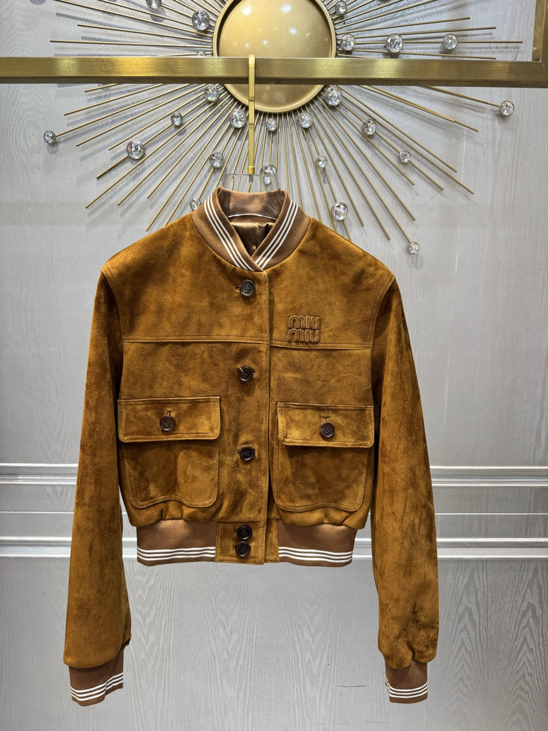 NO:946136,M26 spring and summer series caramel brown suede short jacket, made of soft suede material, combines retro college style with luxurious and rebellious feeling. Short cut + threaded collar, cuffs, hem, metal buttons and double pocket design, practical and detailed. The caramel brown tone is warm and soft, perfect for autumn and winter. It looks great when layered or paired with pleated skirts and overalls, and it is easy to create a sweet and cool retro style. SML, Miu Miu-clothing, skirts, jackets & coats, chamois  leather,19860909M26春夏系列焦糖棕麂皮短款外套,柔软麂皮材质,复古学院风与奢华反叛感兼具.短款剪裁+螺纹领口、袖口、下摆,金属纽扣和双口袋设计,实用又有细节感.焦糖棕色调温暖柔和,秋冬穿搭超适合,叠穿或搭配百褶裙、工装裤都很出彩,轻松打造甜酷复古风 SML,缪缪-服装,skirts,jackets & coats,chamois leather,,Women's clothing