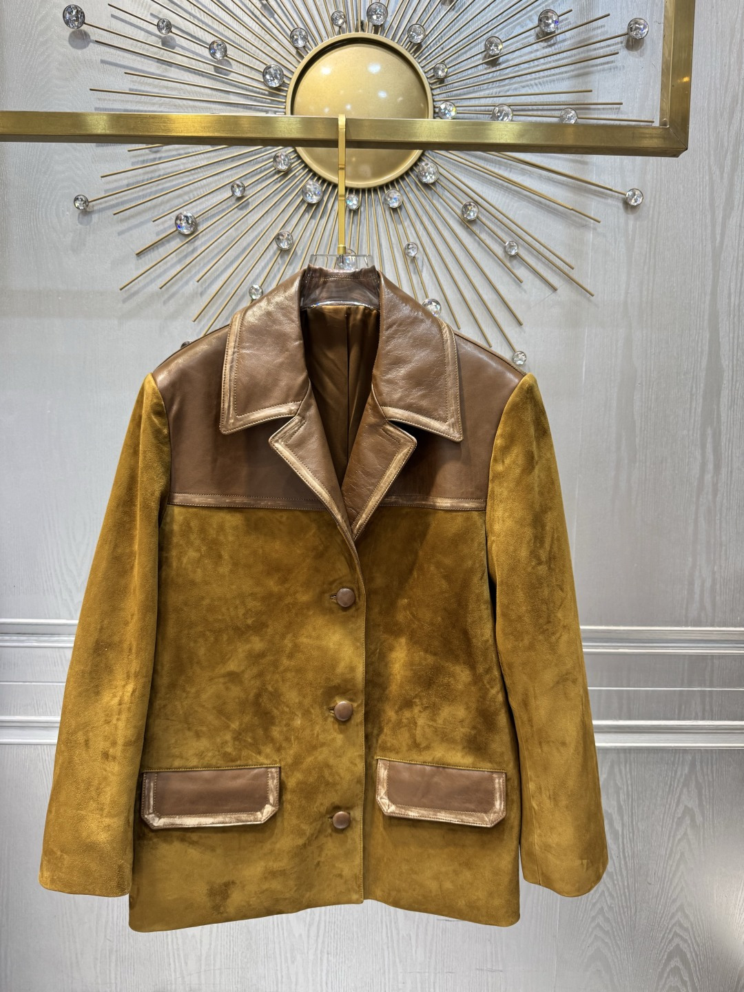 NO:945668,M26 spring and summer series suede splicing jacket, main color is earthy, with dark brown leather lapels and pockets, full of retro and modern feel. Loose silhouette + single-breasted design, easy to put on and take off, practical and fashionable. The suede is soft, and the leather splicing enhances the texture. It is perfect for spring and autumn wear!  Inspired by the 'elegance of work clothes', it pays tribute to the power of women. It can be easily controlled in daily life or activities. Pair it with a floral skirt or work boots, and you can switch between sweet and cool styles at will. S ML, Miu Miu-clothing, boots, skirts, jackets & coats, chamois leather,19860909M26春夏系列麂皮拼接外套,主色土黄,搭配深棕皮革翻领和口袋,复古摩登感满满.宽松廓形+单排扣设计,穿脱方便,兼具实用与时尚感.麂皮柔软,皮革拼接提升质感,春秋季节穿搭超合适！灵感源自“工作服的优雅”,致敬女性力量,日常或活动都能轻松驾驭,搭配碎花裙或工装靴,甜酷风格随心切换. S ML,缪缪-服装,boots,skirts,jackets & coats,chamois leather,,Women's clothing